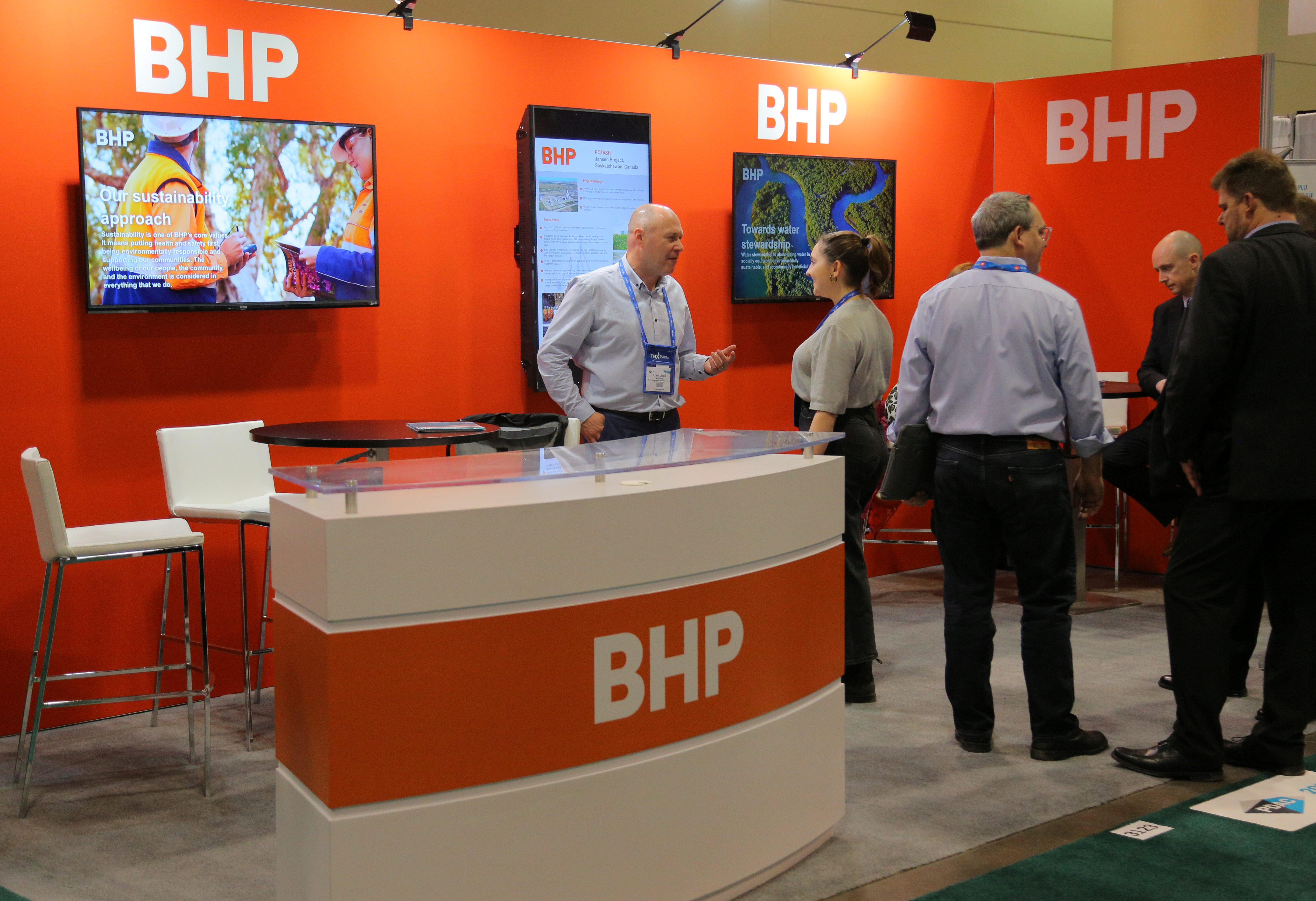 Visitors to the BHP (formerly known as BHP Billiton) booth speak with representatives during the Prospectors and Developers Association of Canada (PDAC) annual convention in Toronto, Ontario, Canada March 4, 2019. REUTERS/Chris Helgren