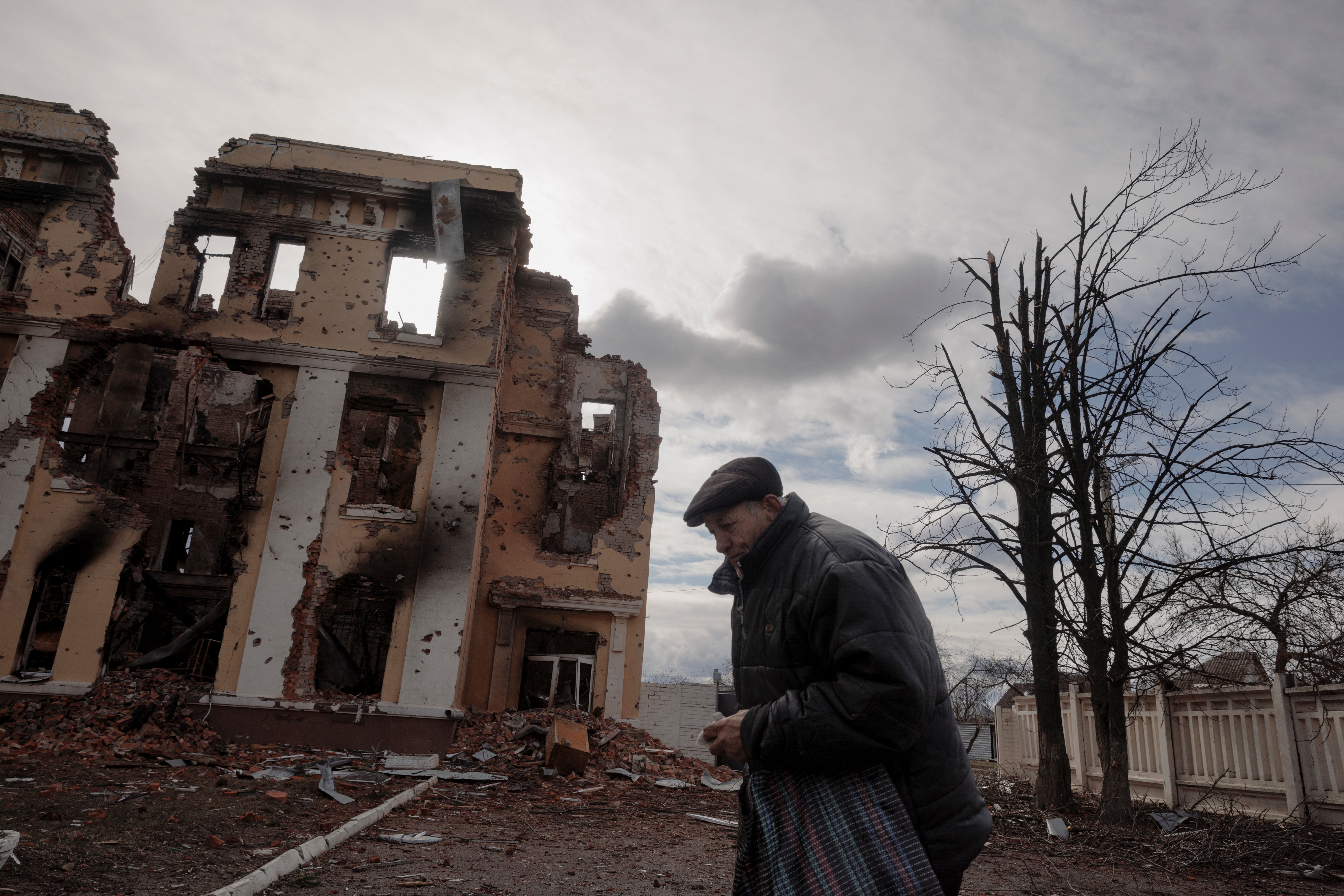 A man walks past a school that was damaged by fighting in Kharkiv as Russia's attack on Ukraine continues