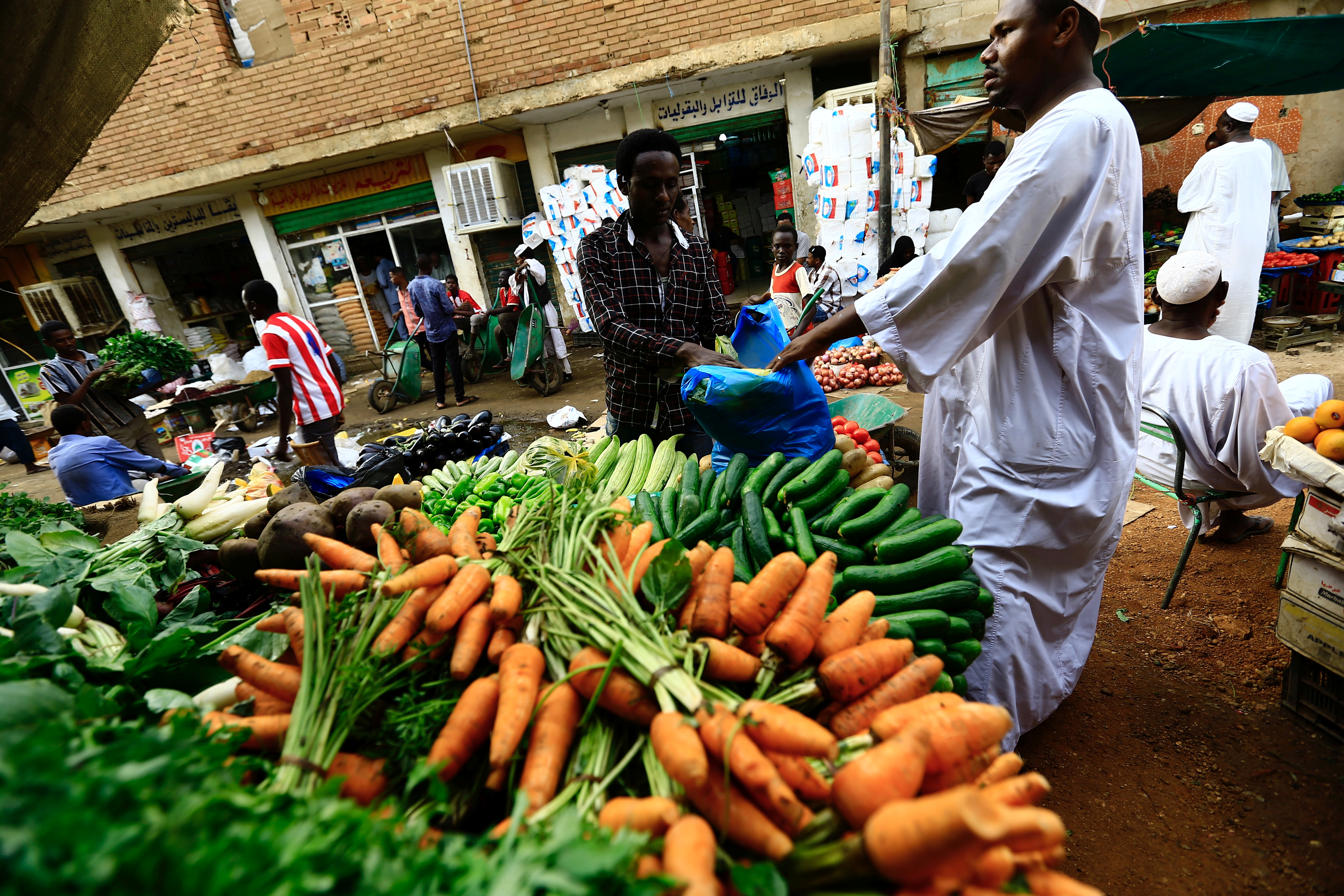 A man waits to buy food at a market in Khartoum