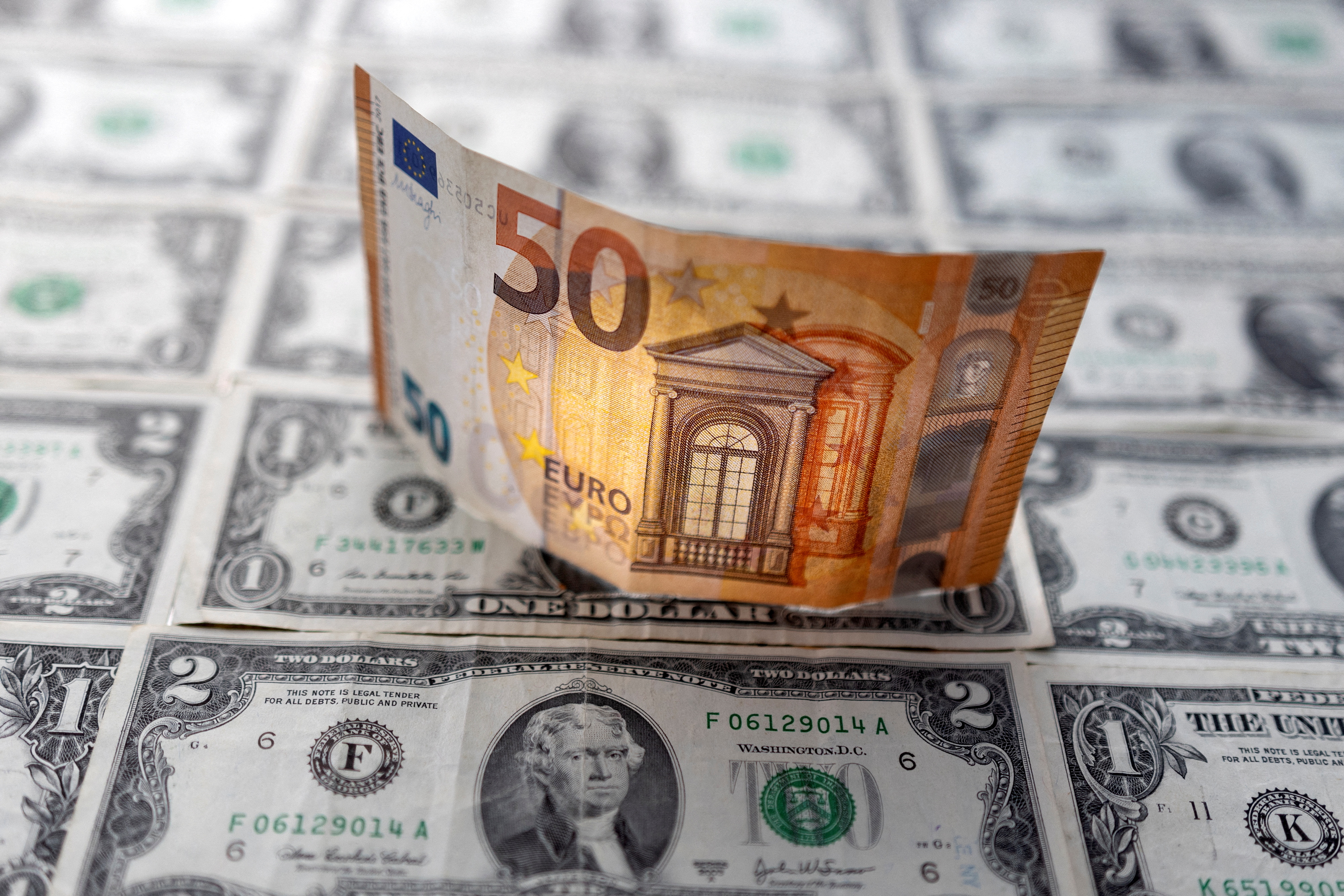 Illustration shows Euro banknote placed on U.S. Dollar banknotes