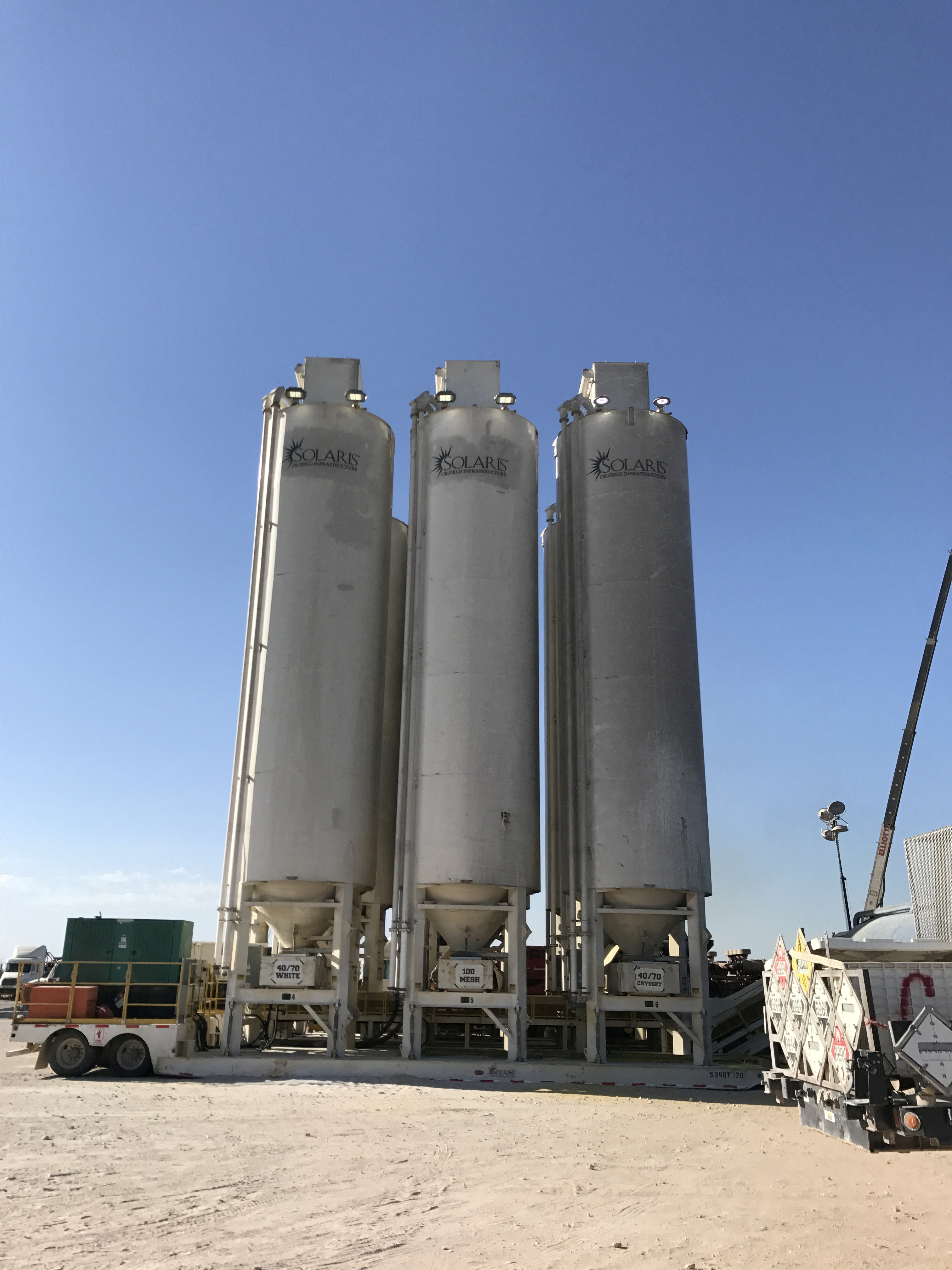 Tanks holding sand that will be used to hydraulically fracture, or frack, an Exxon Mobil Corp oil well are seen near Midland