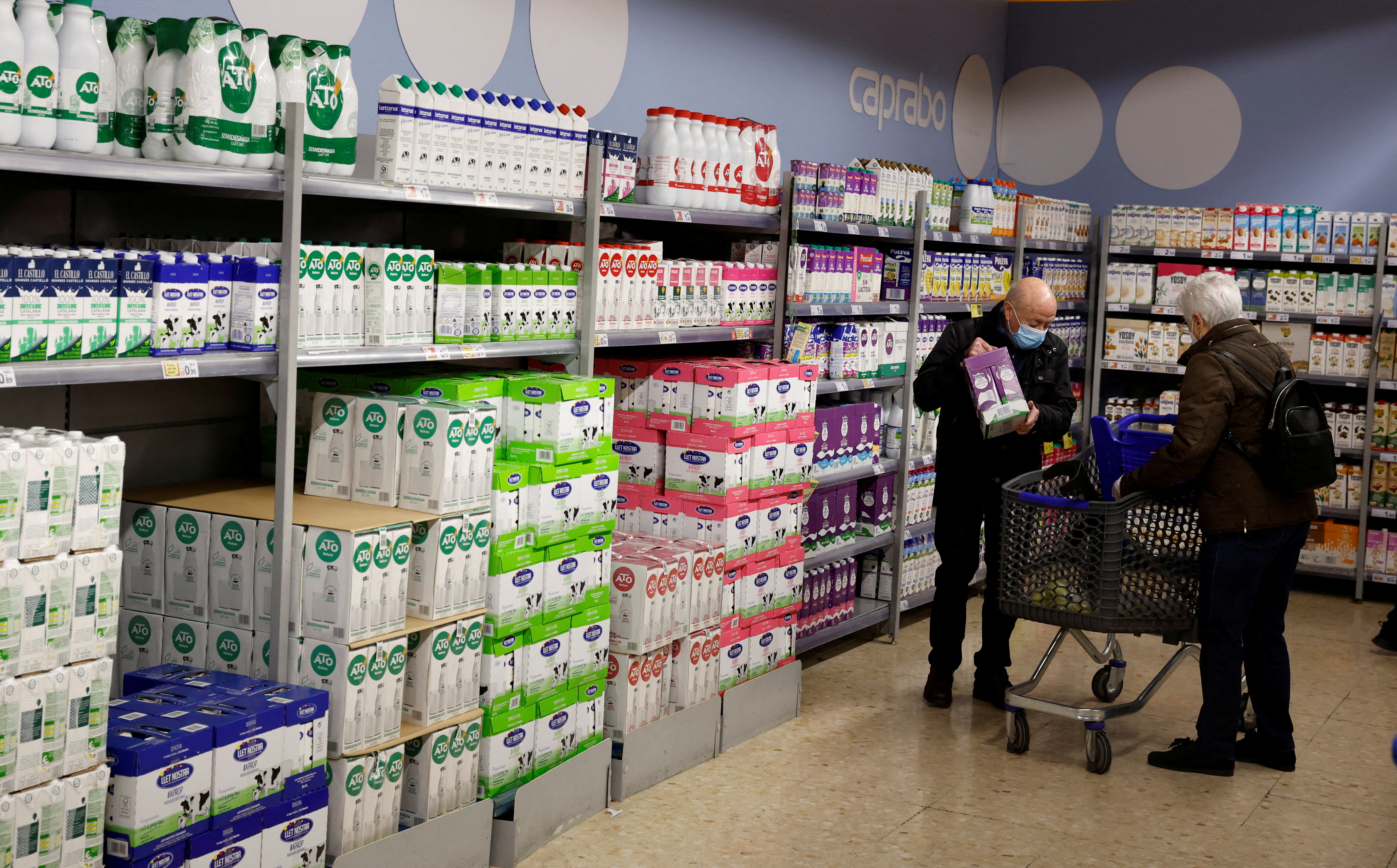 A couple takes some milk in a Caprabo supermarket in Barcelona