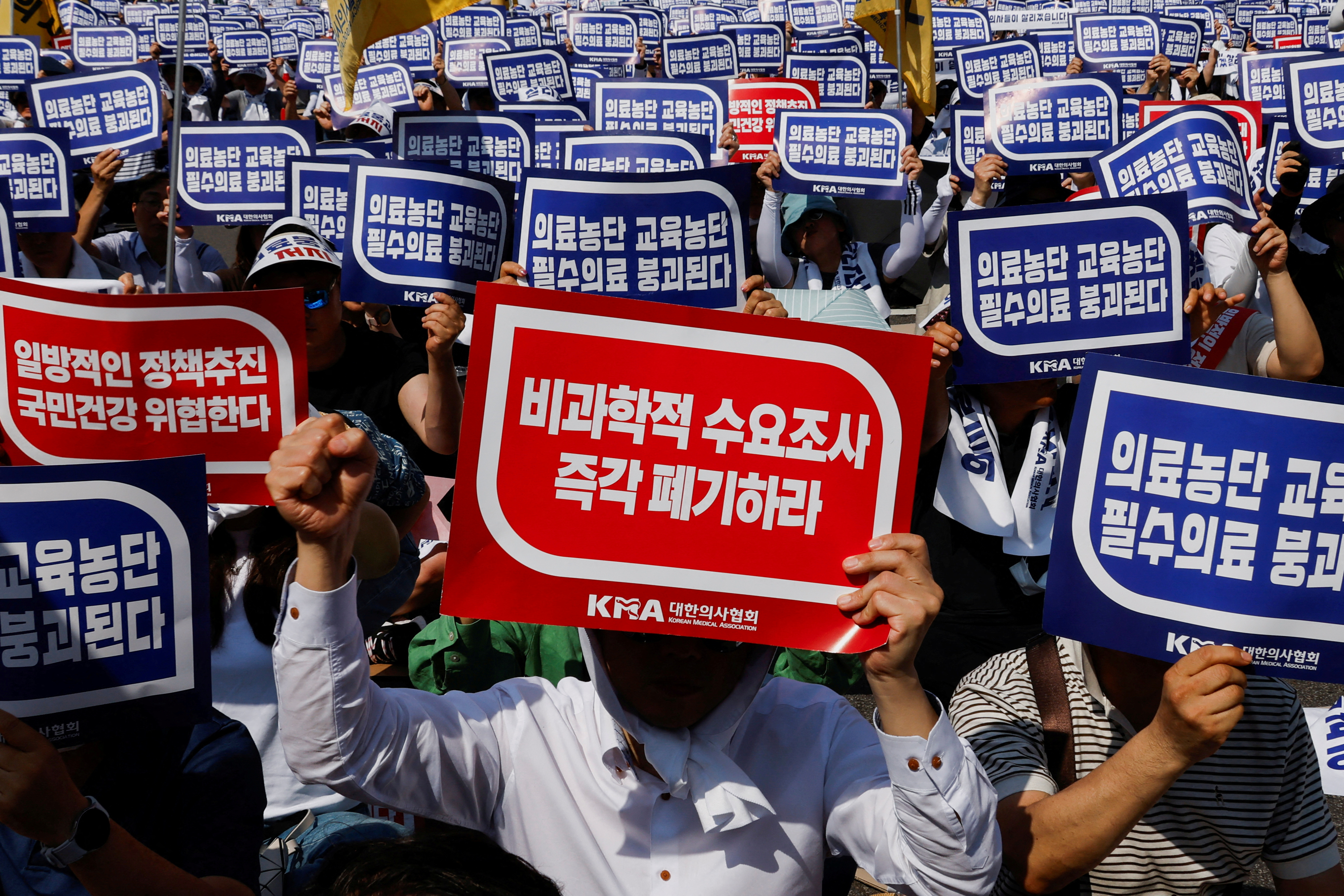Doctors strike and shout slogans during a rally to protest against government plans to increase medical school admissions and healthcare reform in Seoul