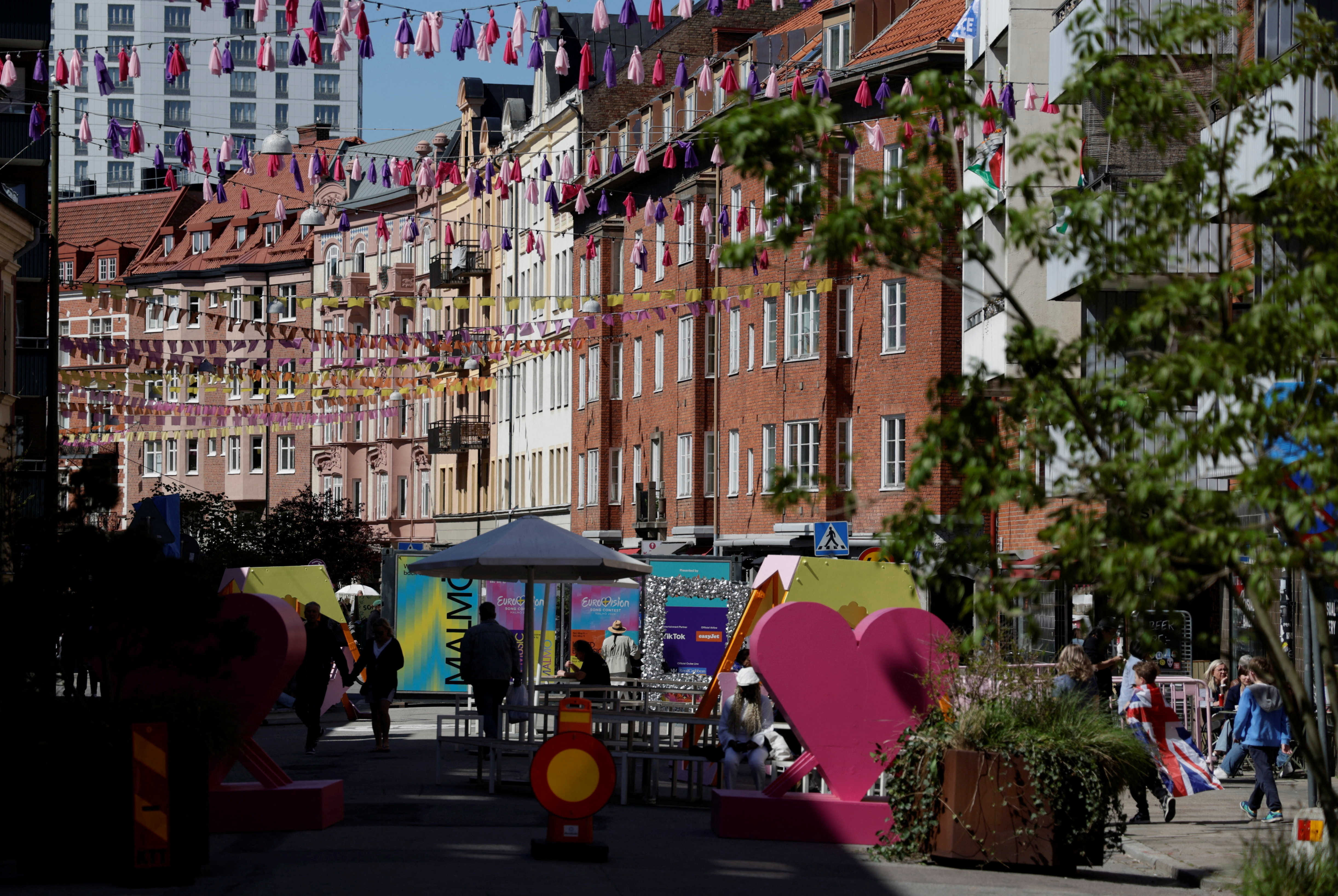 People walk down a street decorated for the Eurovision Song Contest in Malmo