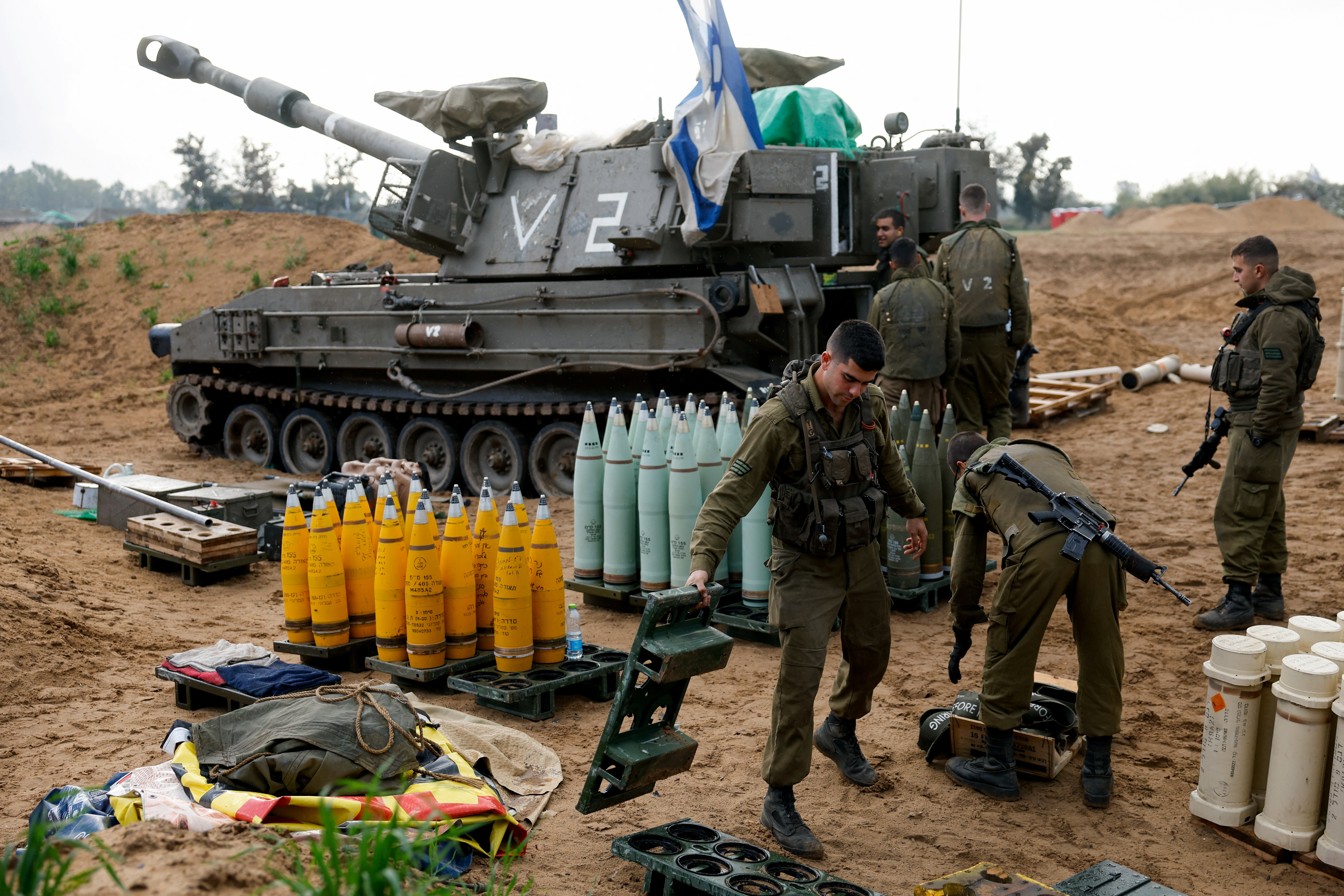 Israeli soldiers prepare shells near a mobile artillery unit in Israel