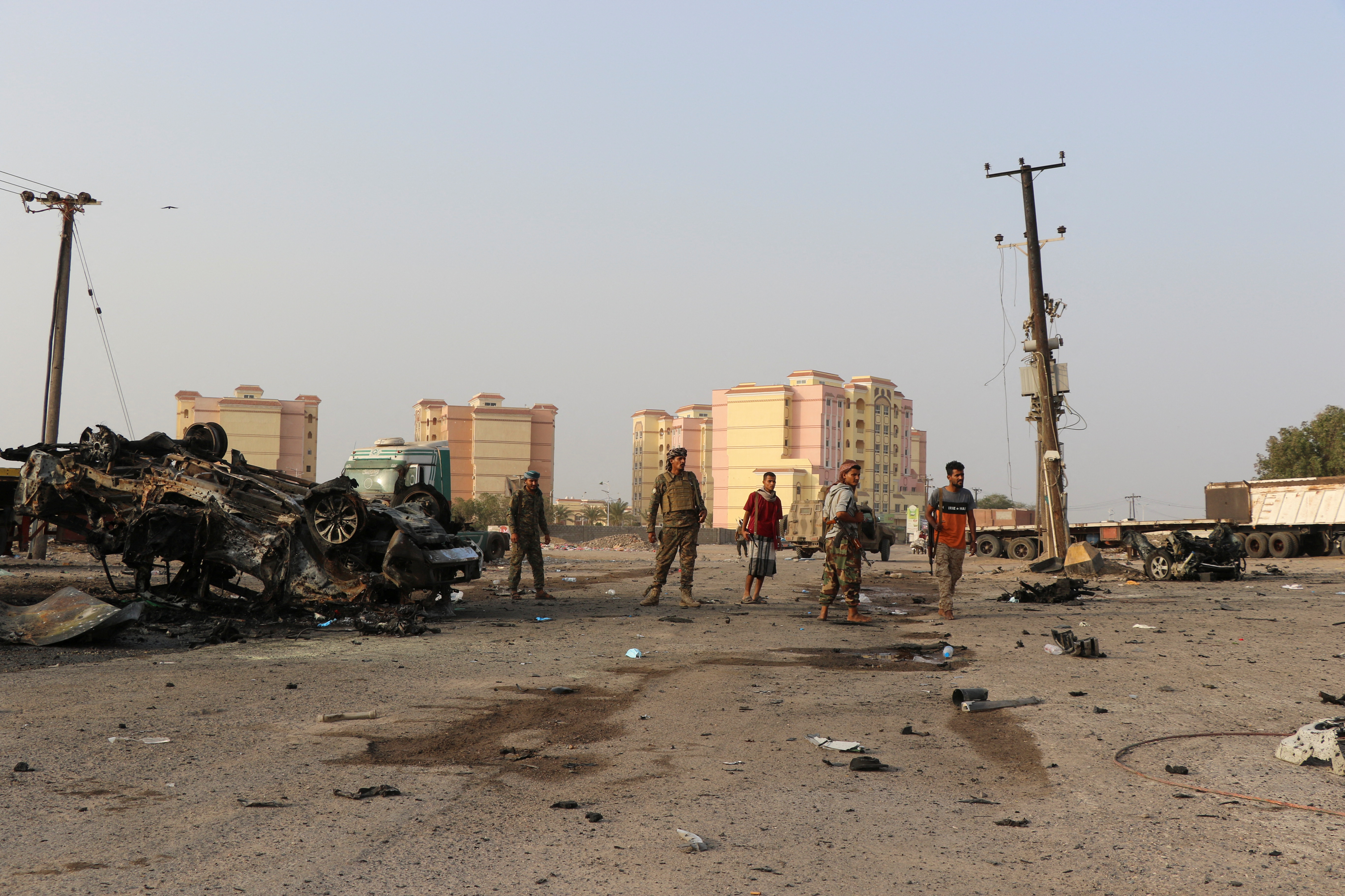 Soldiers stand by the wreckage of a vehicle at the scene of a car bomb attack in the southern port city of Aden