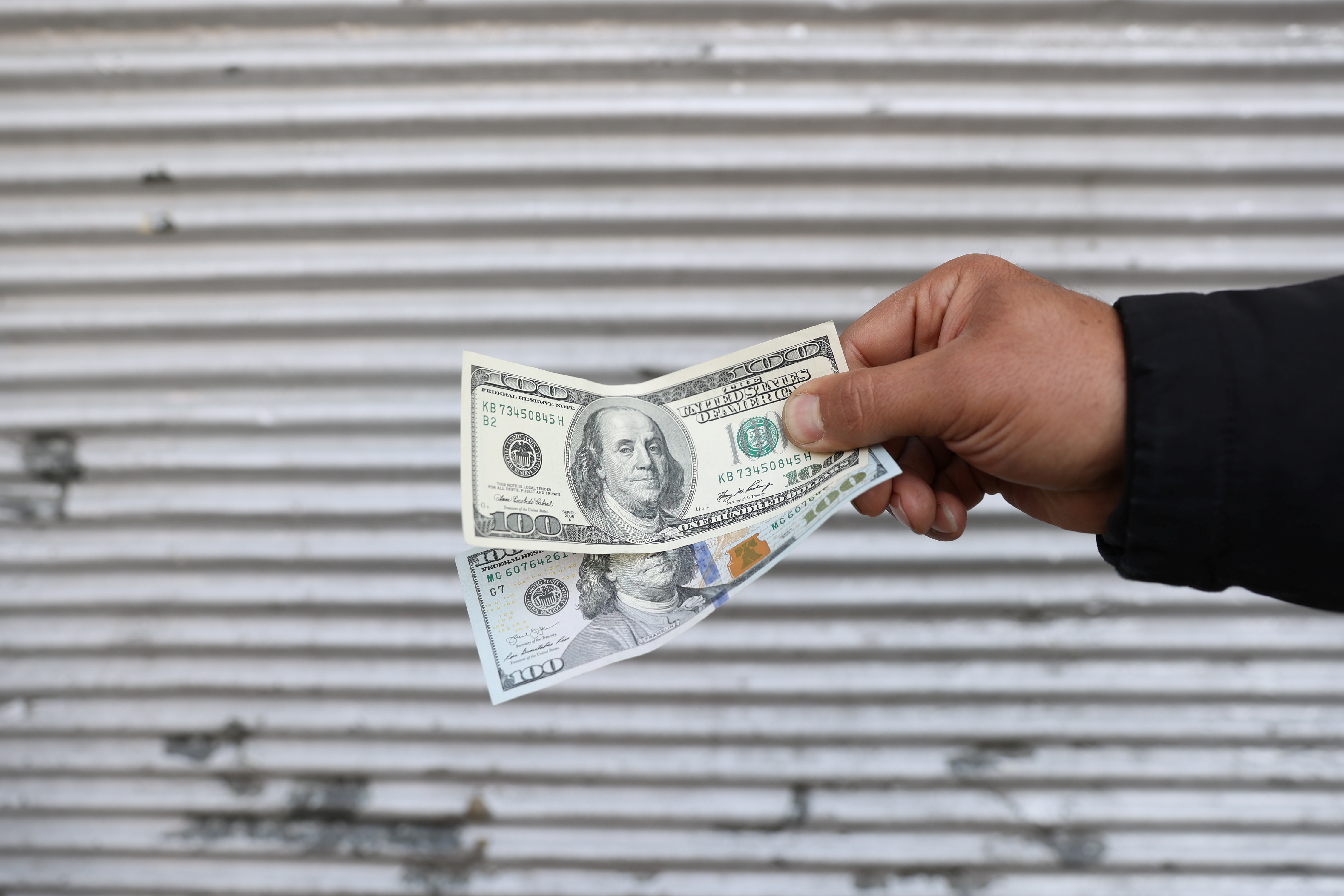 A street-side currency vendor holds U.S. dollars at Ferdowsi Square in Tehran