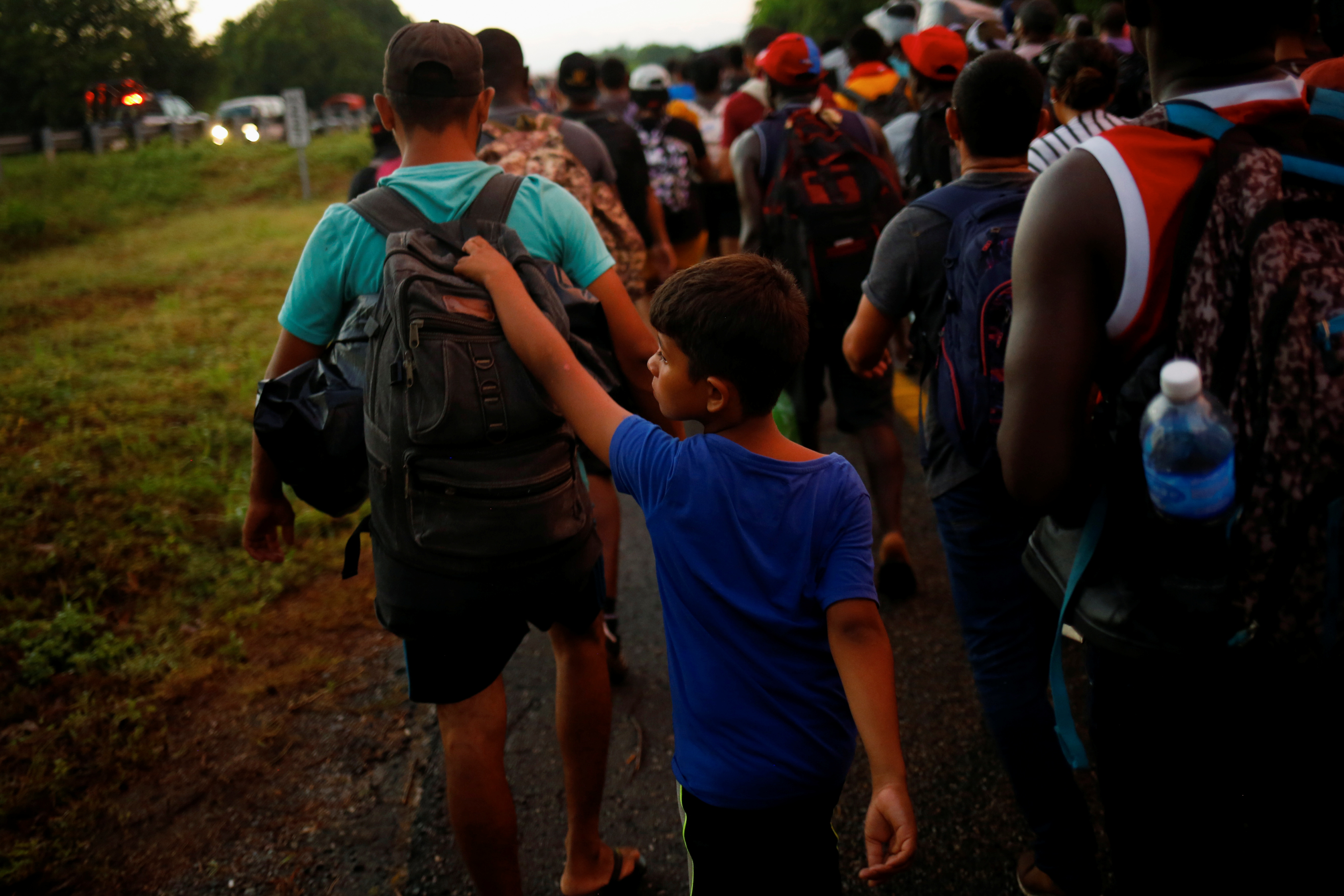 Xabiel, 9, a migrant from Venezuela walks with his brother Yilber Gabriel as they join the caravan heading to the U.S. border, near Villa Comaltitlan, Mexico November 20, 2021. REUTERS/Jose Luis Gonzalez