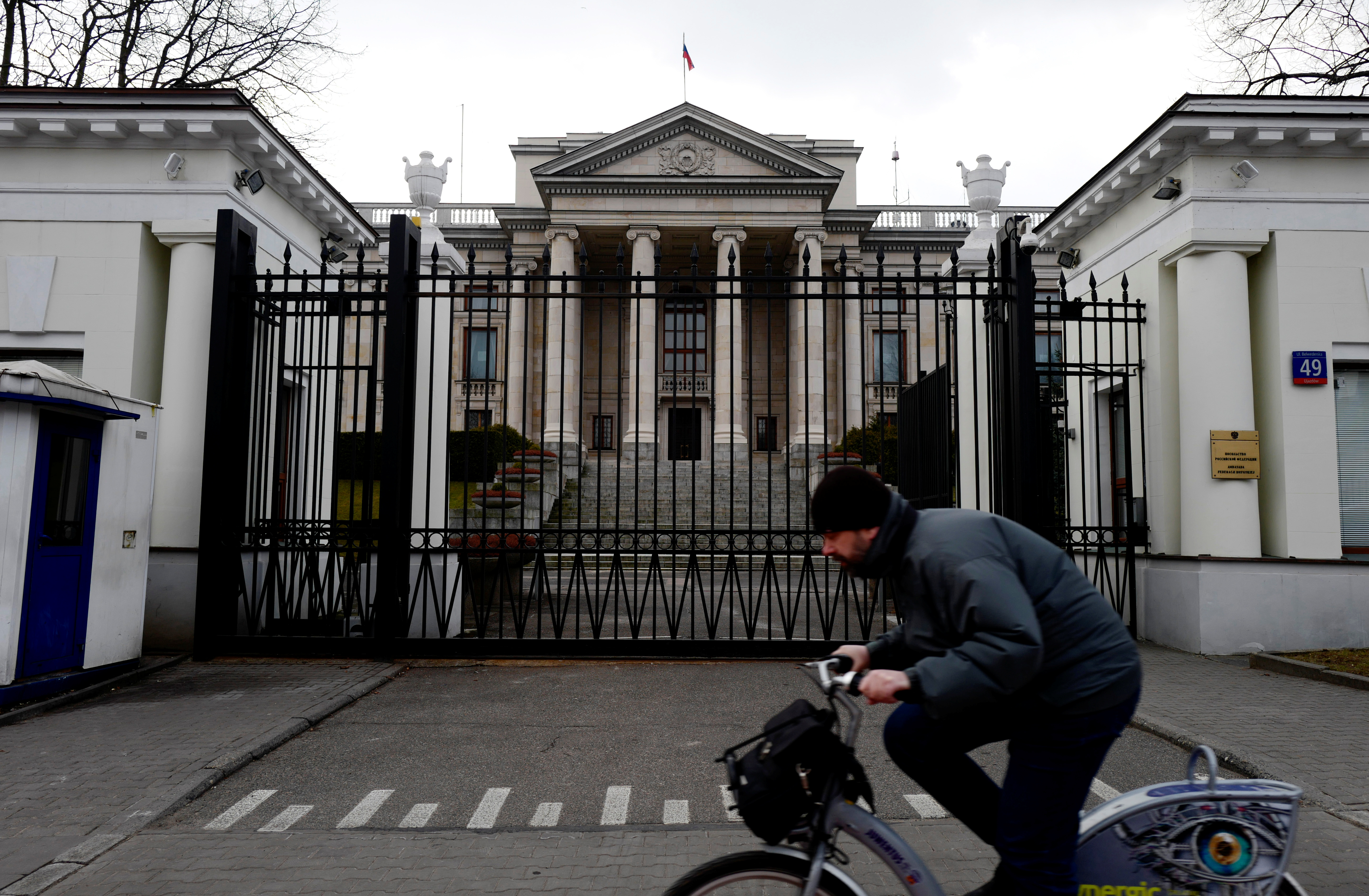 Man rides a bicycle in front of the Russian embassy building in Warsaw