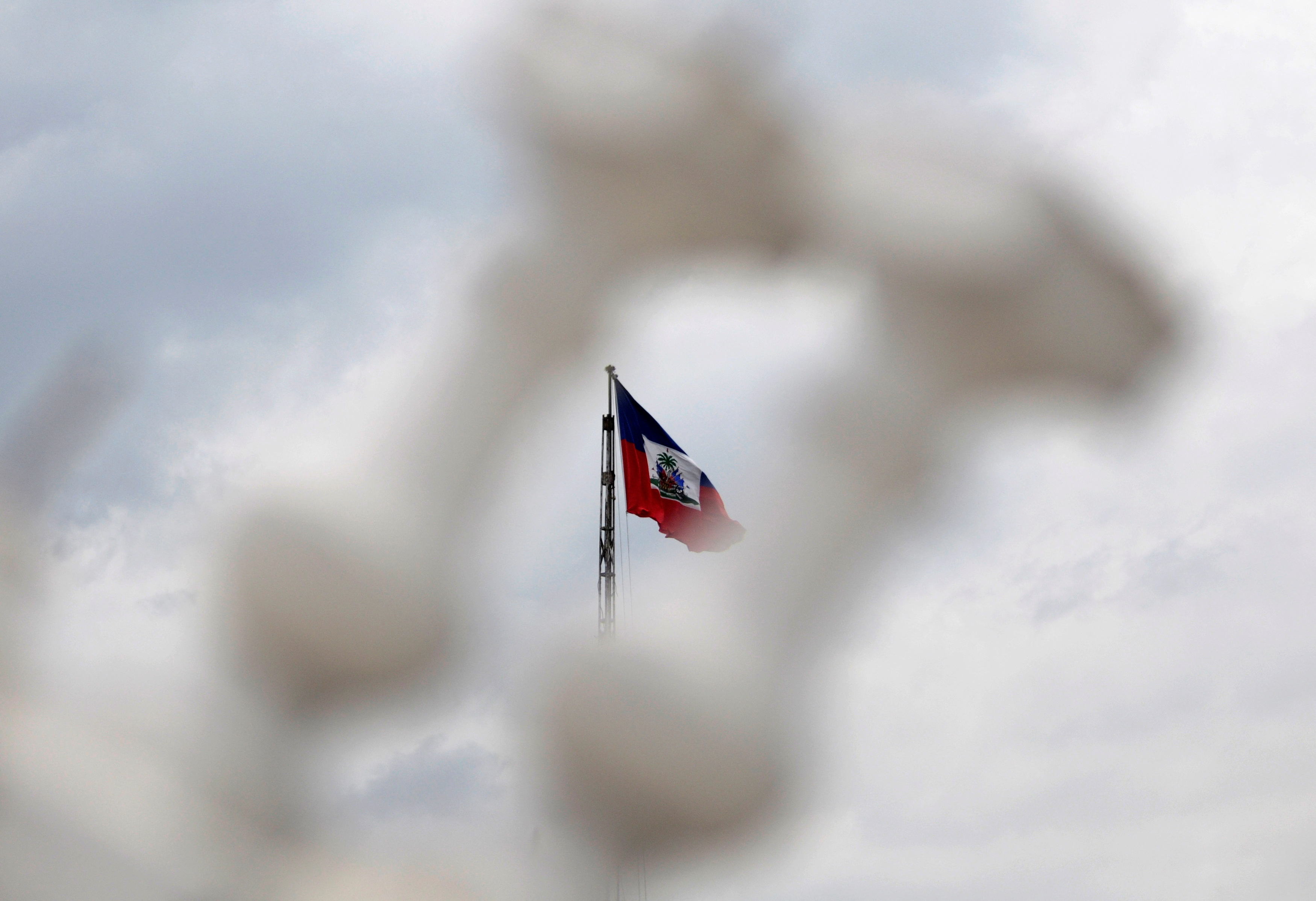 The Haitian flag photographed through two of balusters remaining on balcony of collapsed National Palace,flies from a pole in Port-au-Prince