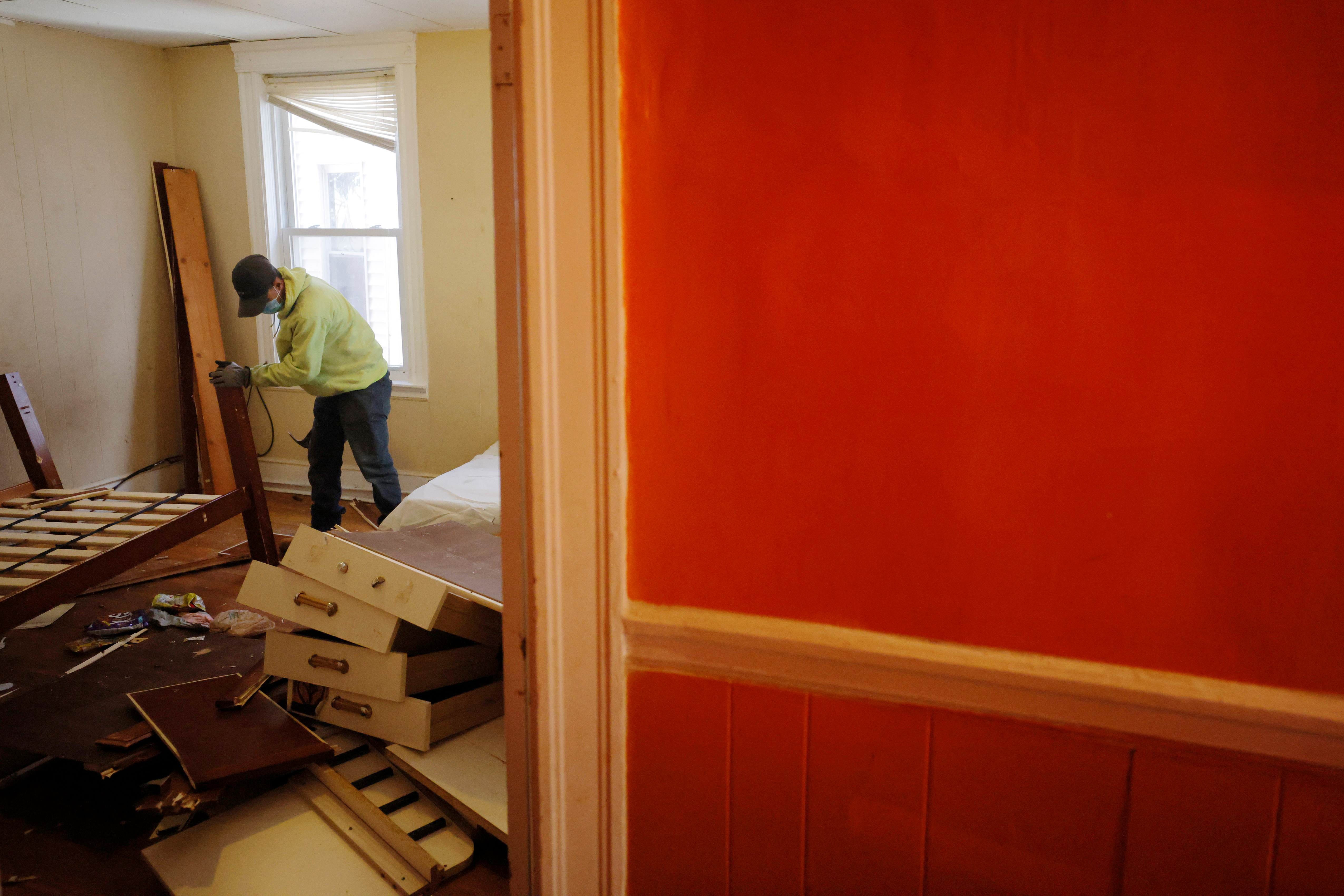 Workers break up the furniture left by a renter who was evicted after a 48-hours notice for violating the terms of her lease in Chelsea, Massachusetts, U.S., March 29, 2021. REUTERS/Brian Snyder