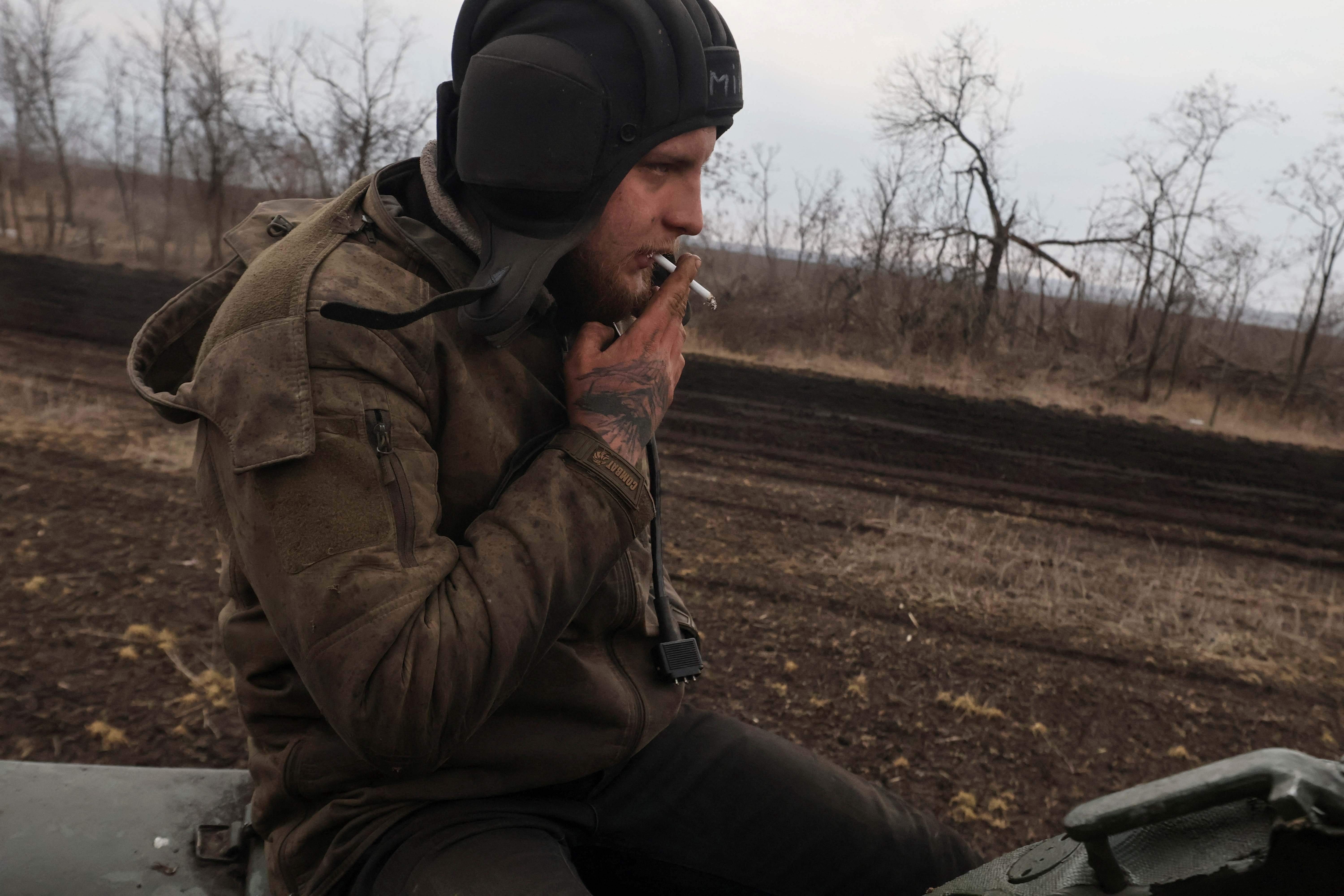 Ukrainian serviceman smokes as he rides on a tank near the frontline town of Bakhmut