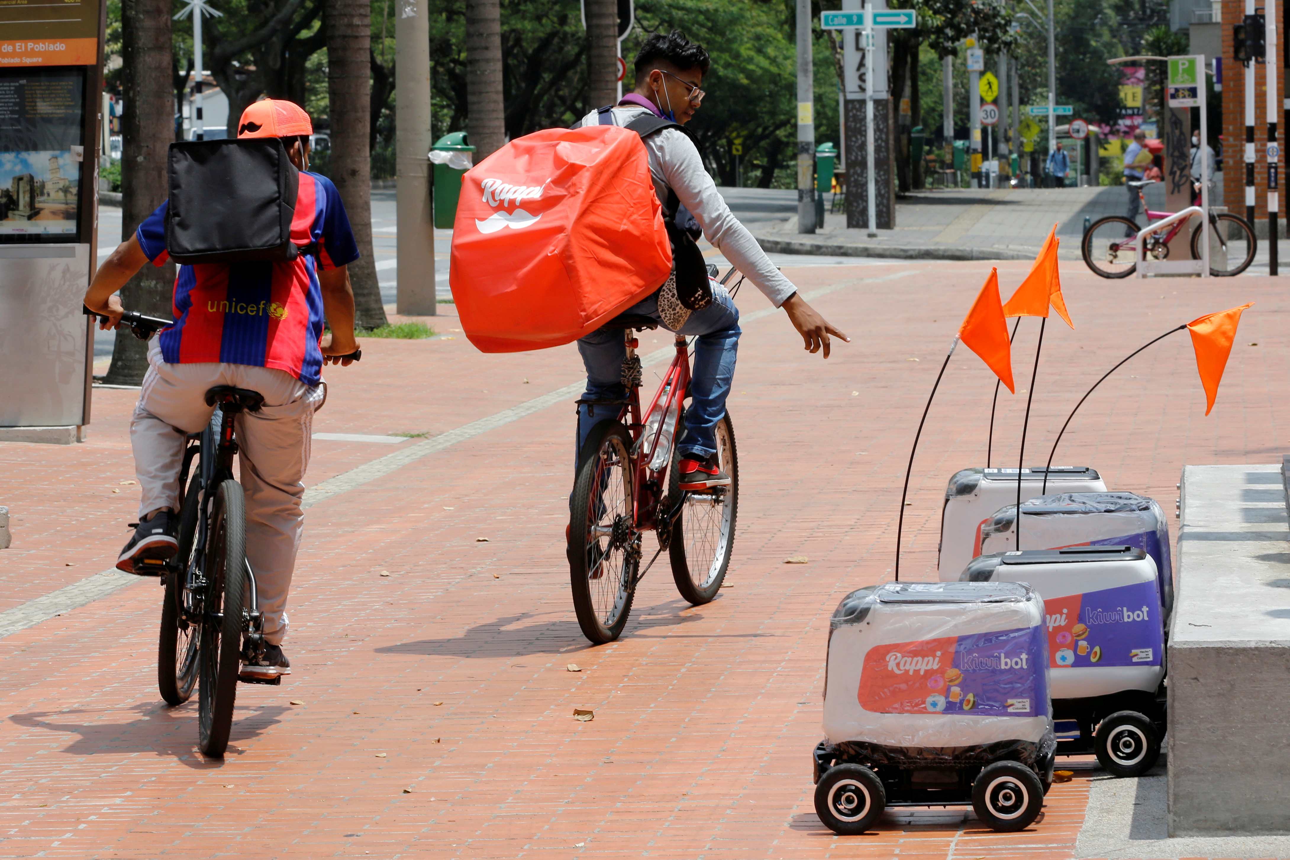 Rappi delivery workers observe delivery robots from the Colombian company Rappi in Medellin