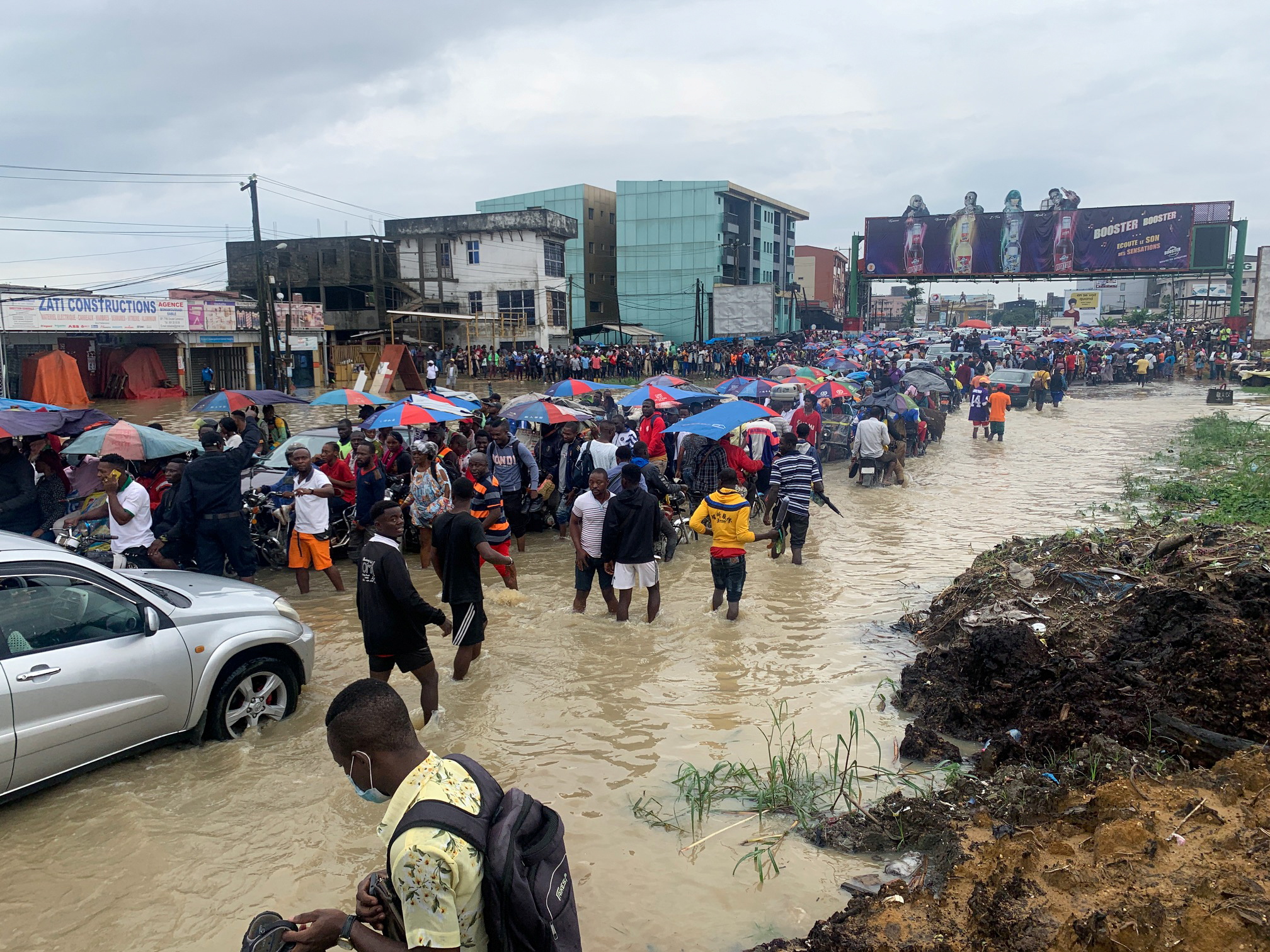 People make their way through a flooded street after the heavy rains in Douala