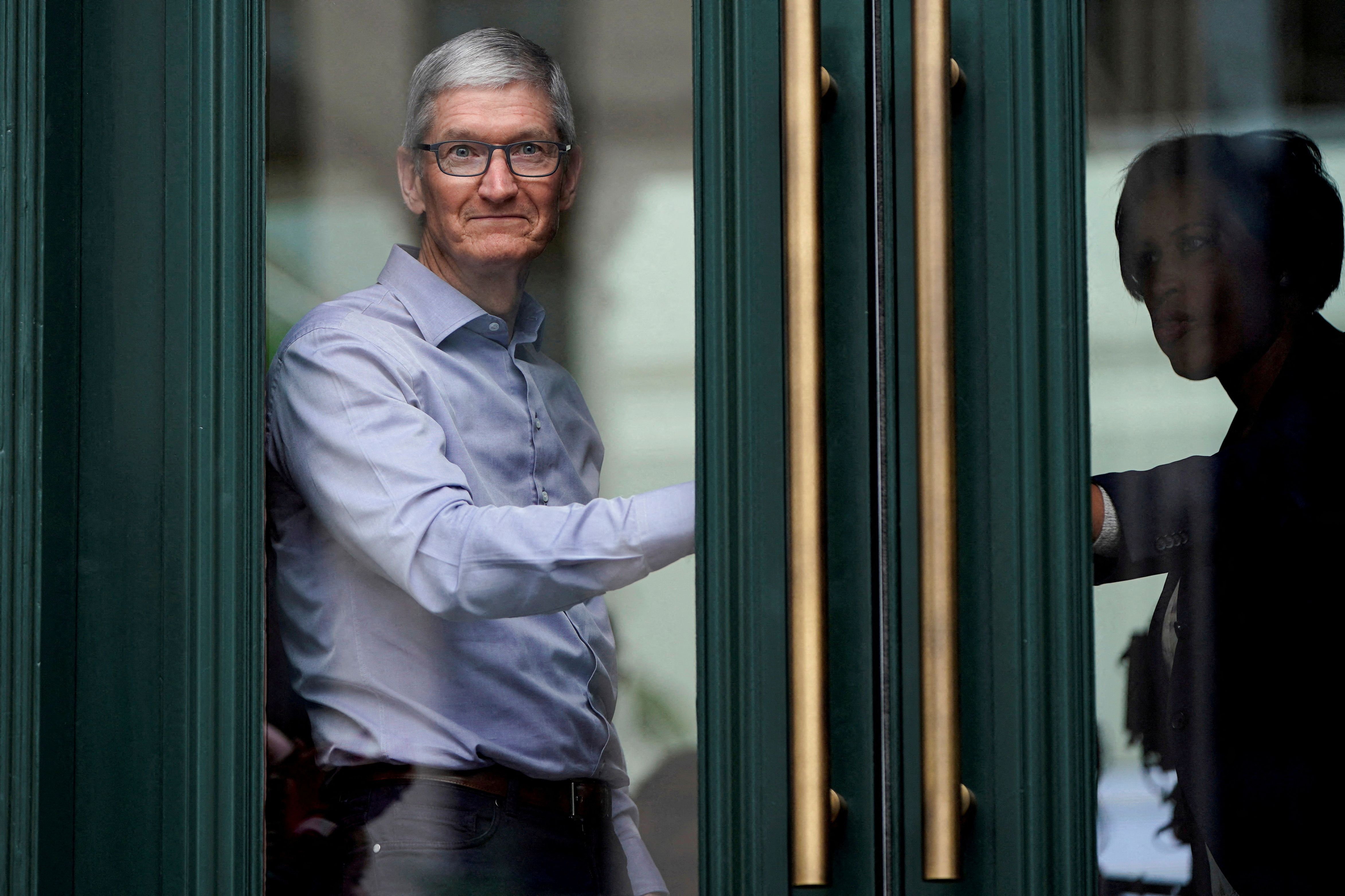 FILE PHOTO: pple Chief Executive Officer Tim Cook watches customers awaiting the grand opening of the new Apple Carnegie Library store in Washington