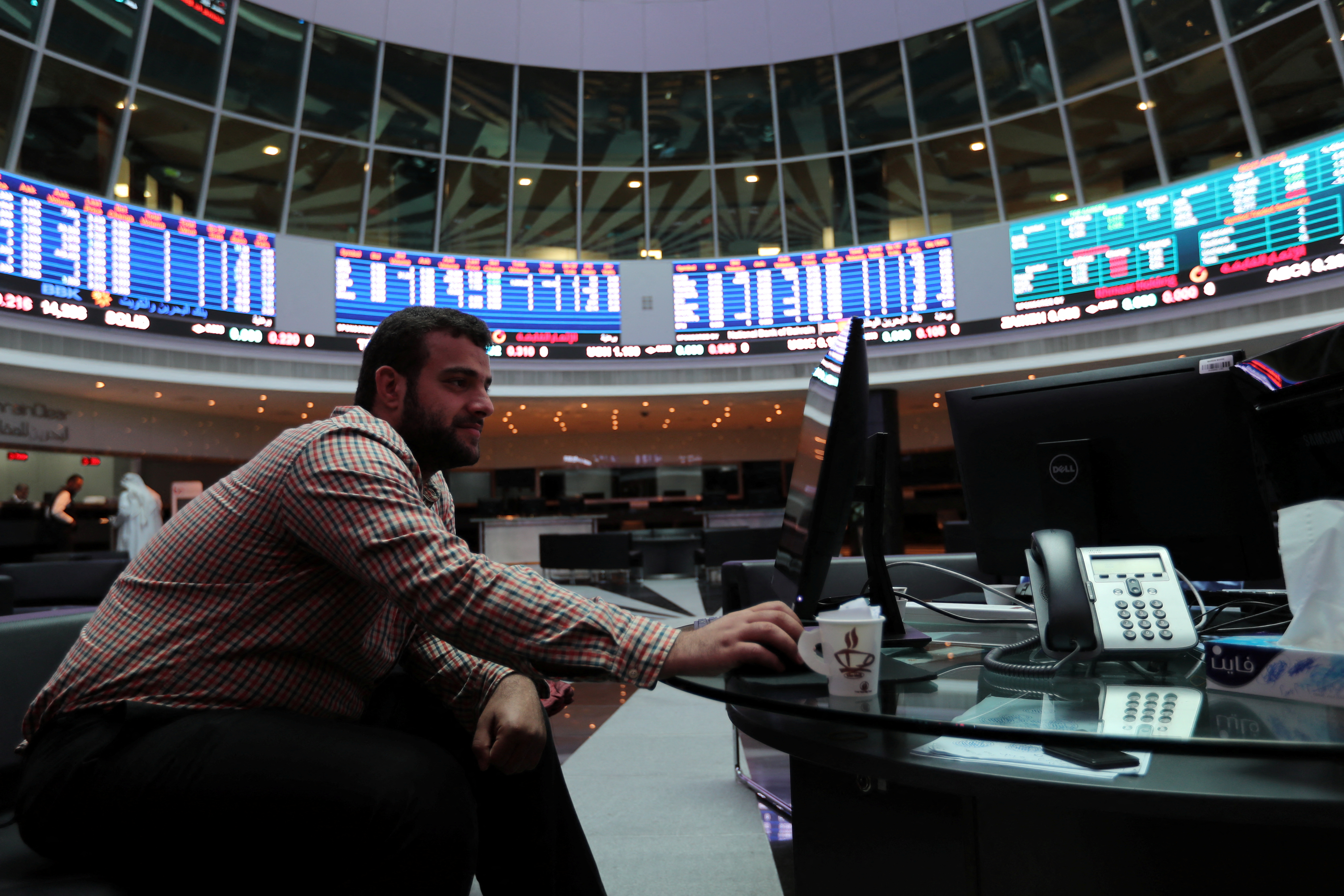 A trader looks at the screens at Bahrain Bourse in Manama
