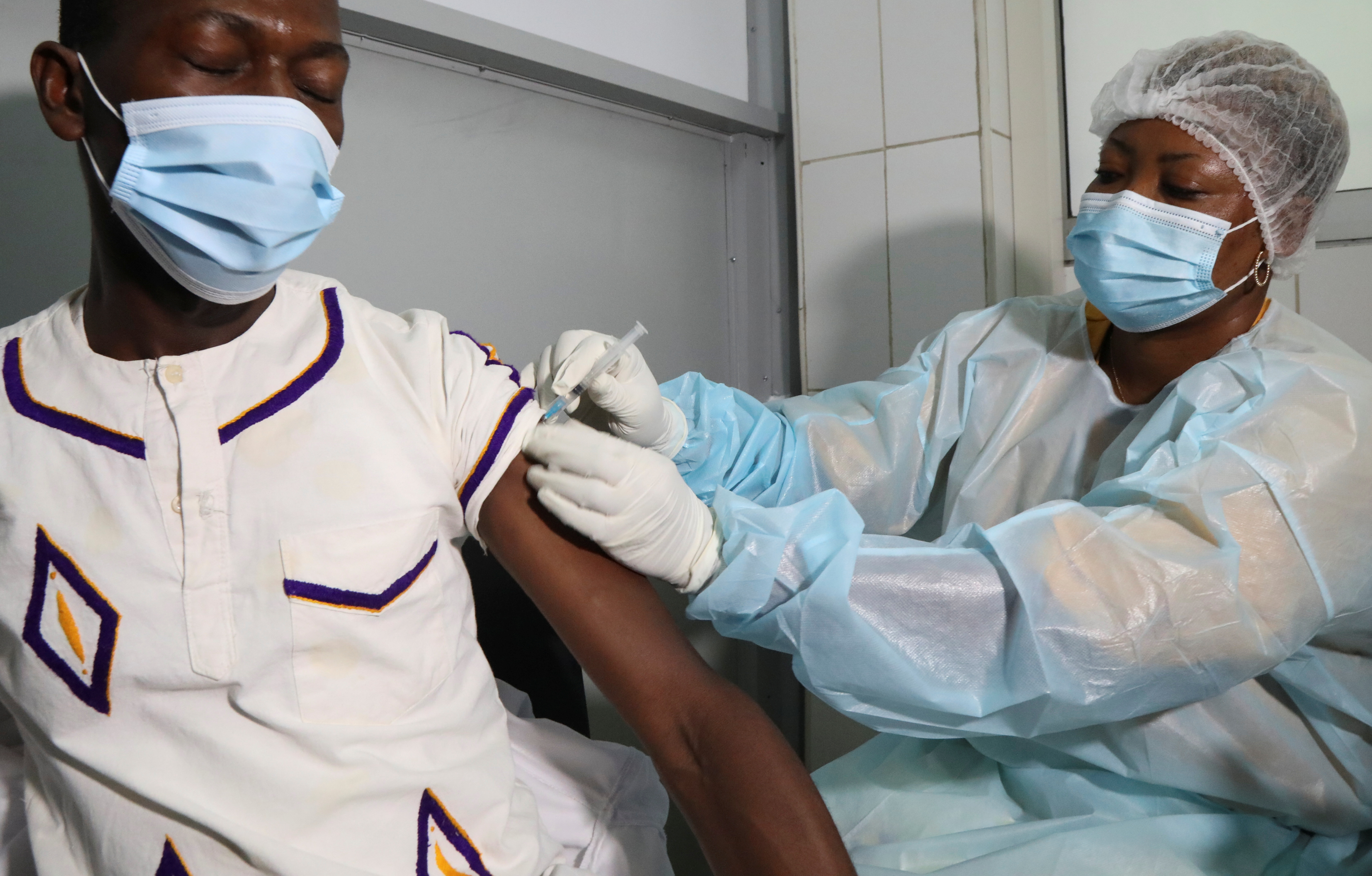 A health worker receives a vaccine against Ebola at a hospital after a case of Ebola was confirmed in Abidjan