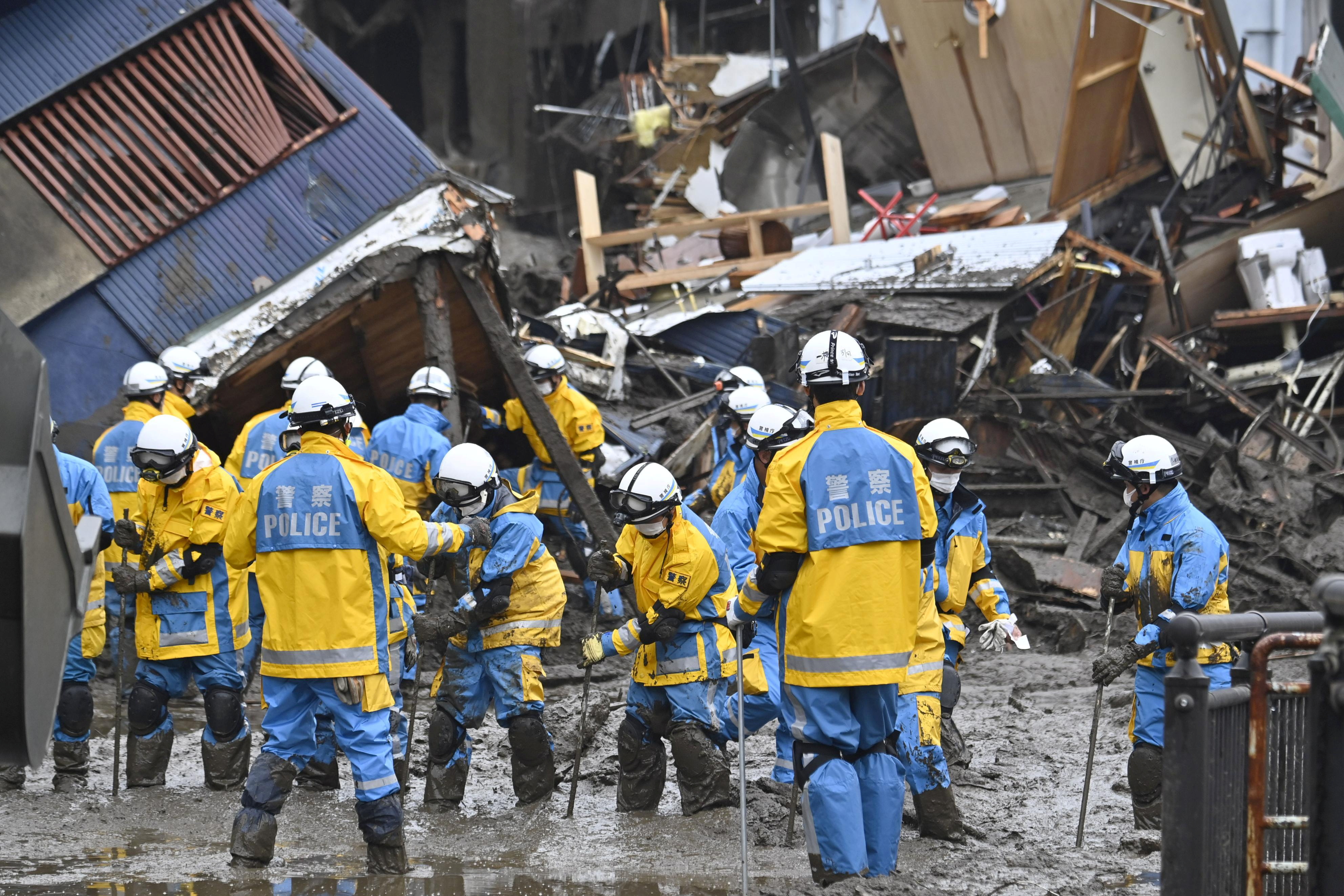 Полицейские проводят поисково-спасательную операцию на месте оползня, вызванного сильным дождем, в районе Идзусан в Атами, к западу от Токио, Япония, 4 июля 2021 года, на этой фотографии, сделанной Kyodo.  Kyodo / через REUTERS