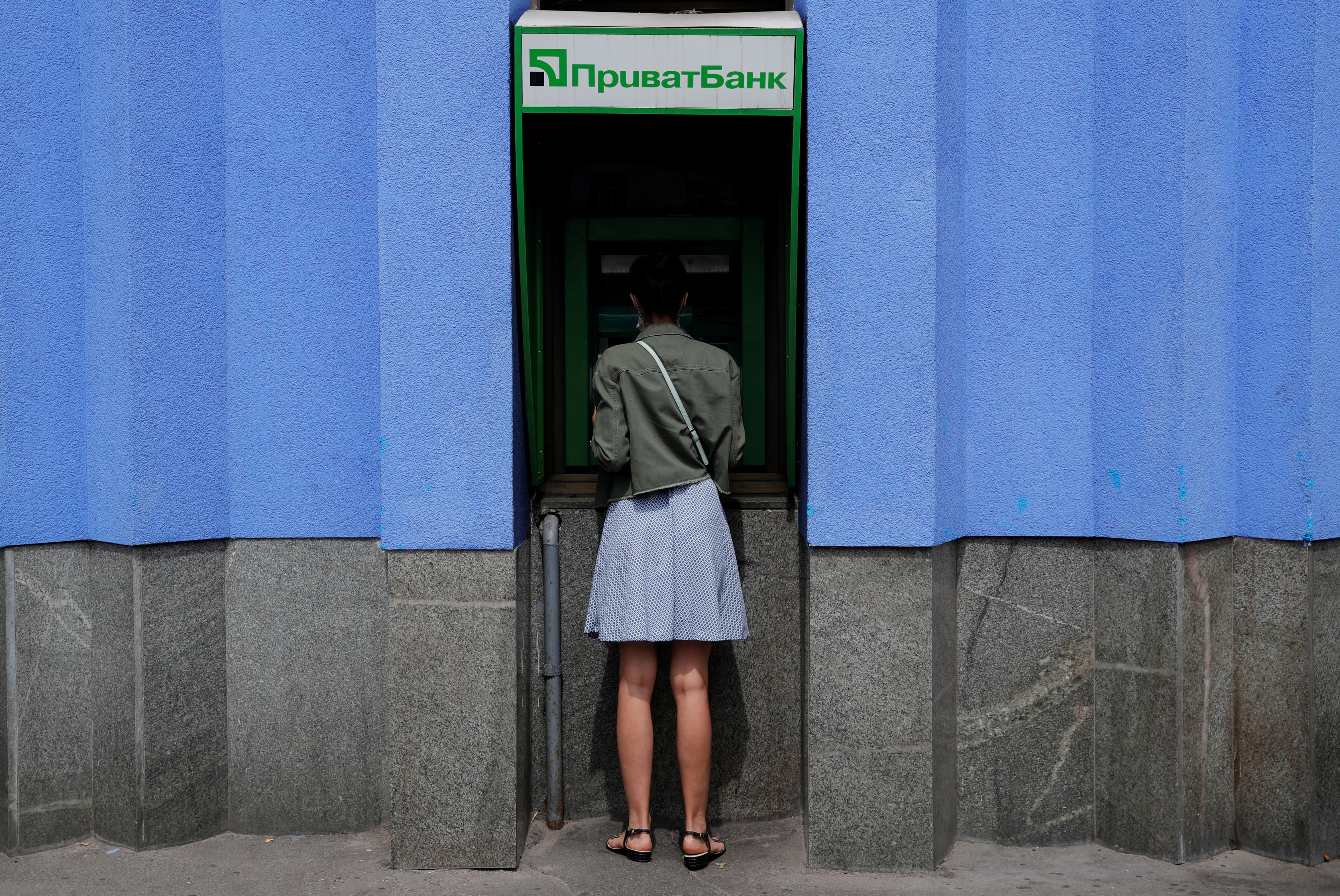 A woman uses a PrivatBank ATM machine in Kyiv