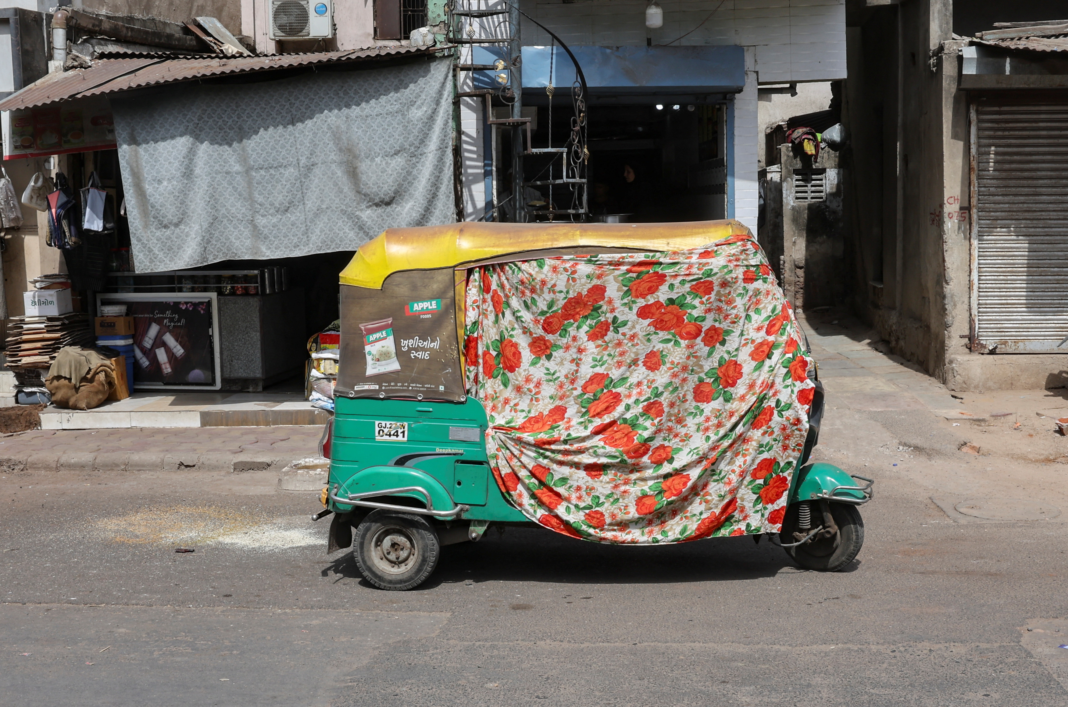 An autorickshaw covered with a cloth is seen on the street during a heat wave in Ahmedabad