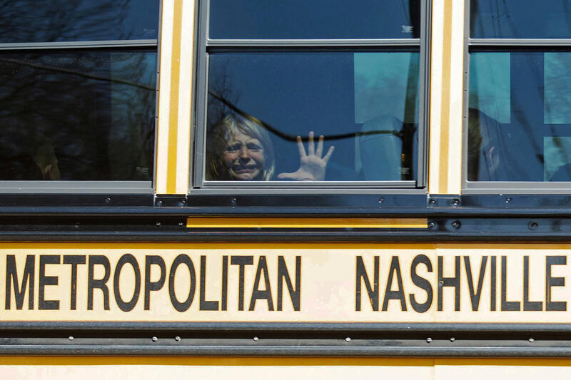 A child weeps while on the bus leaving The Covenant School, following a mass shooting in Nashville