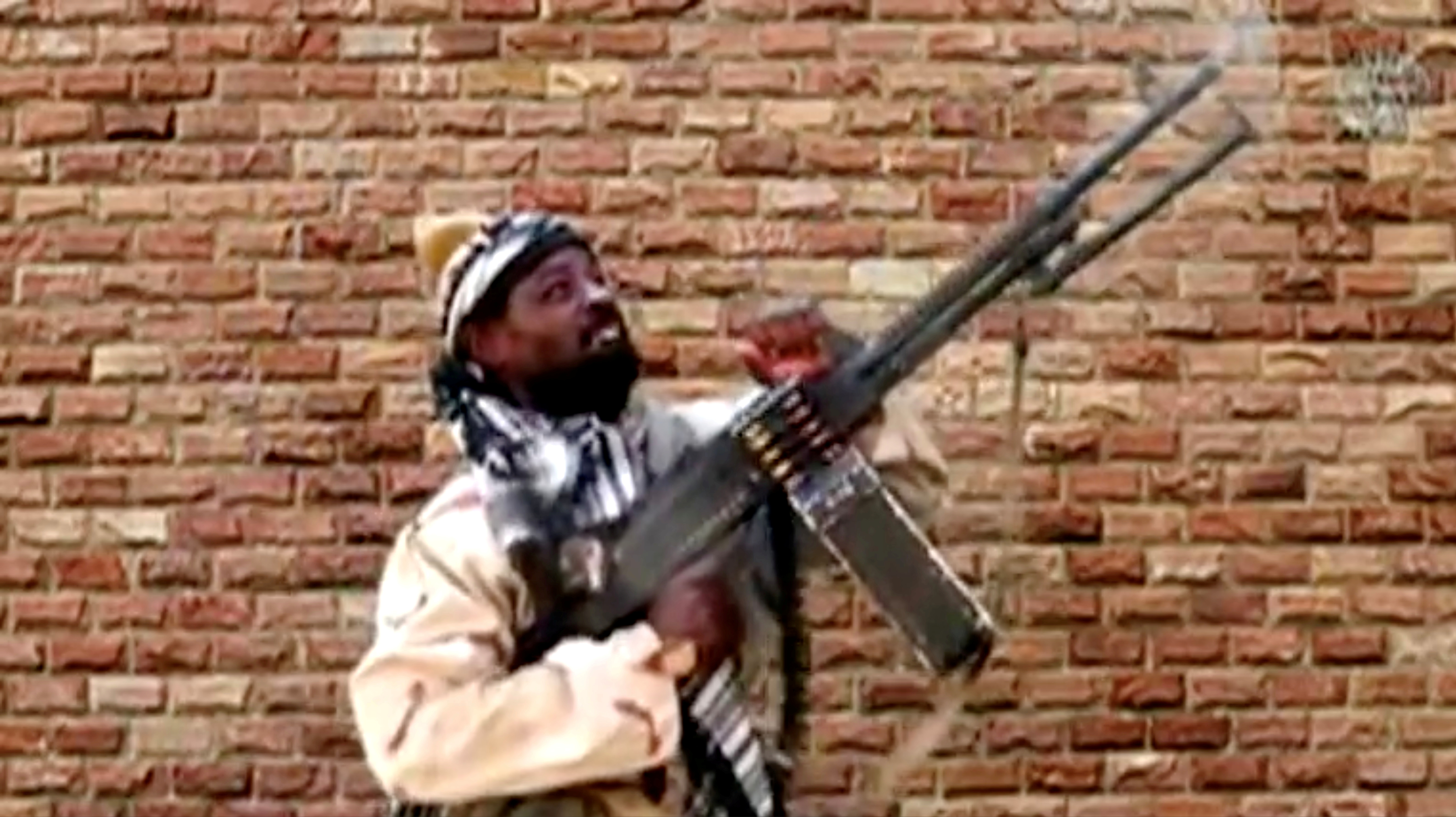 Leader of one of the Boko Haram group's factions, Abubakar Shekau fires from a weapon in an unknown location in Nigeria