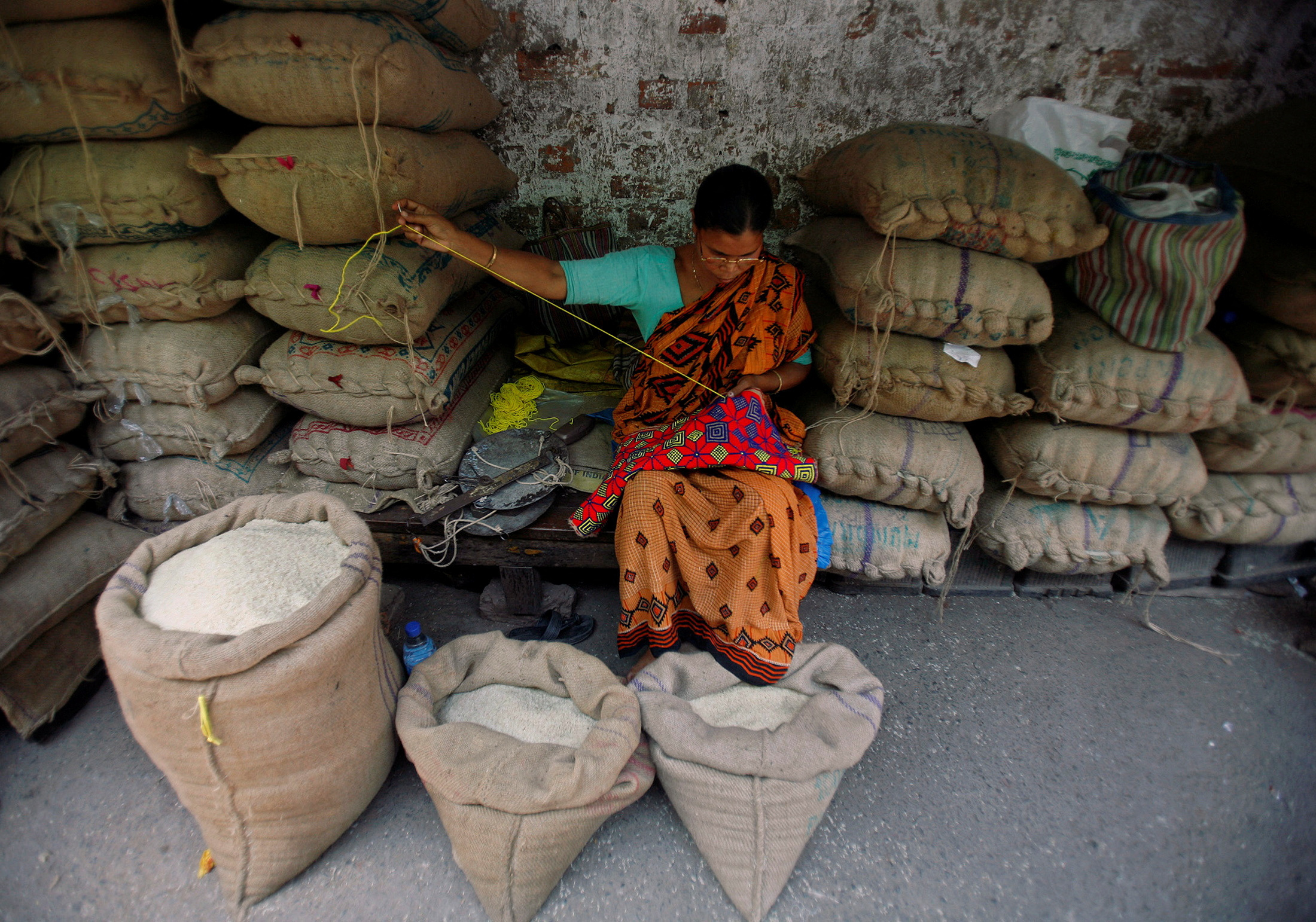 Shopkeeper sews at rice wholesale market in Kolkata