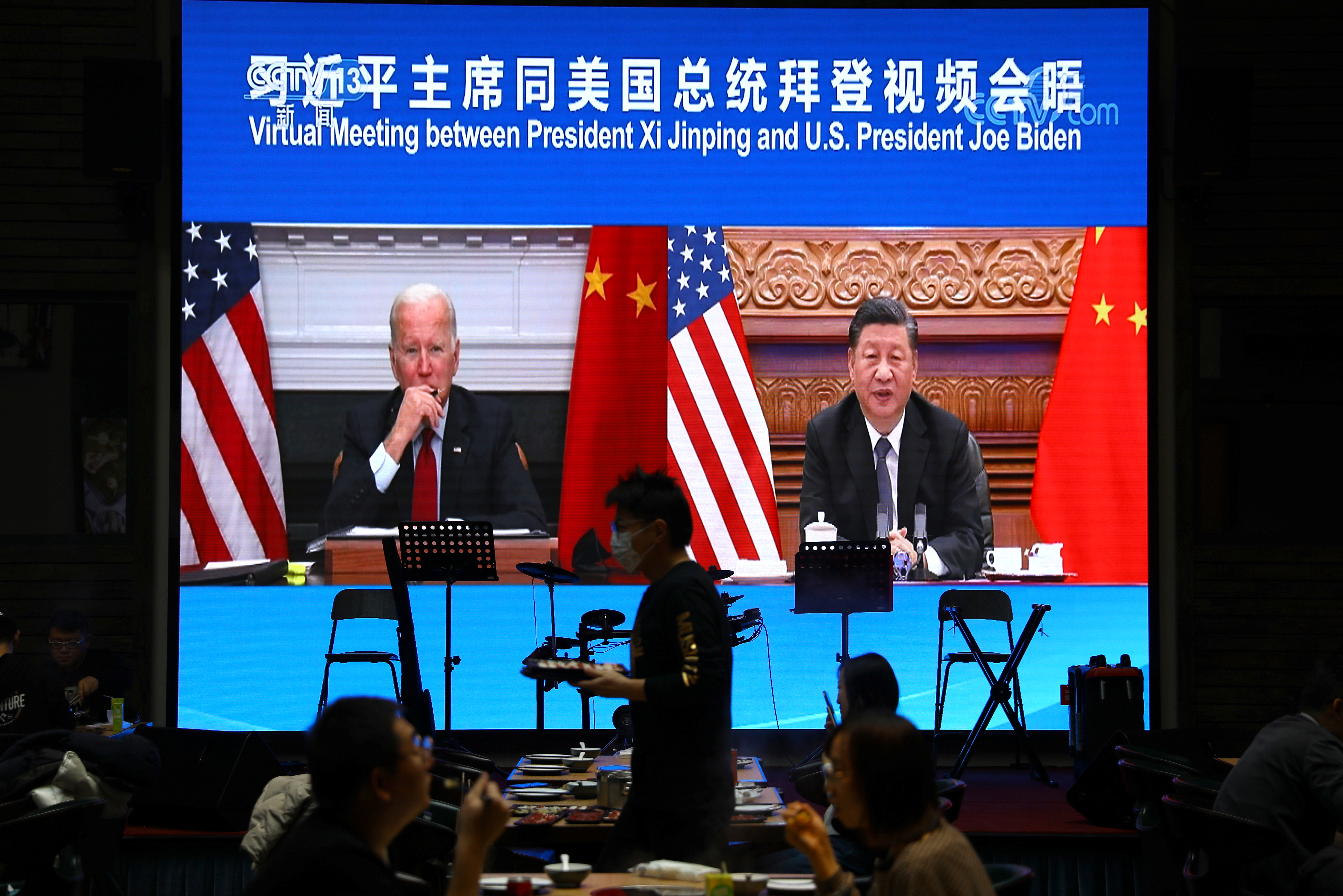 Una pantalla muestra un enlace de video del presidente chino Xi Jinping asistiendo a una reunión virtual con el presidente estadounidense Joe Biden el 16 de noviembre de 2021 en un restaurante en Beijing, China.  REUTERS / Tingshu Wang