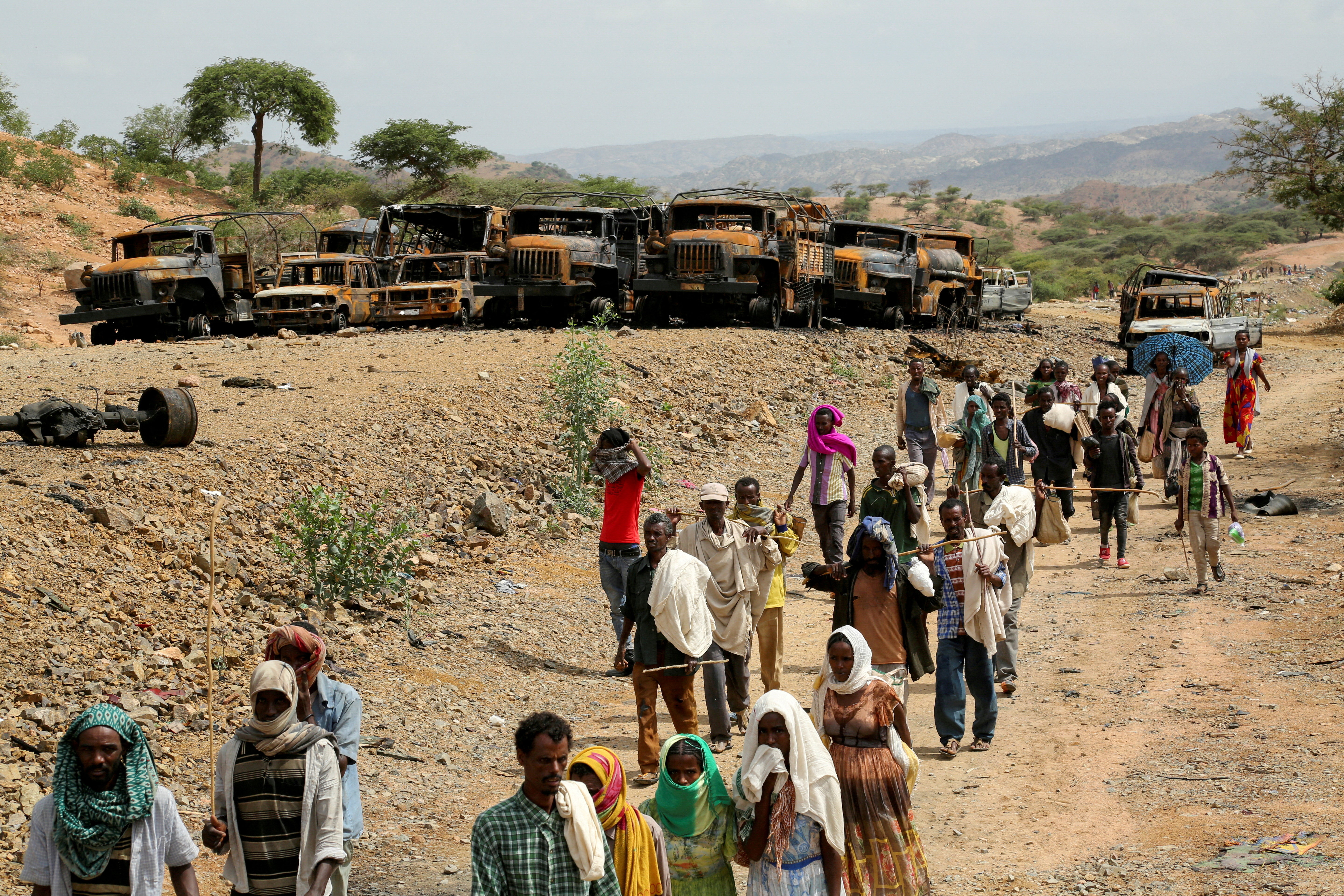 Villagers return from a market to Yechila town in south central Tigray walking past scores of burned vehicles, in Tigray, Ethiopia, July 10, 2021. REUTERS/Giulia Paravicini/File Photo/File Photo