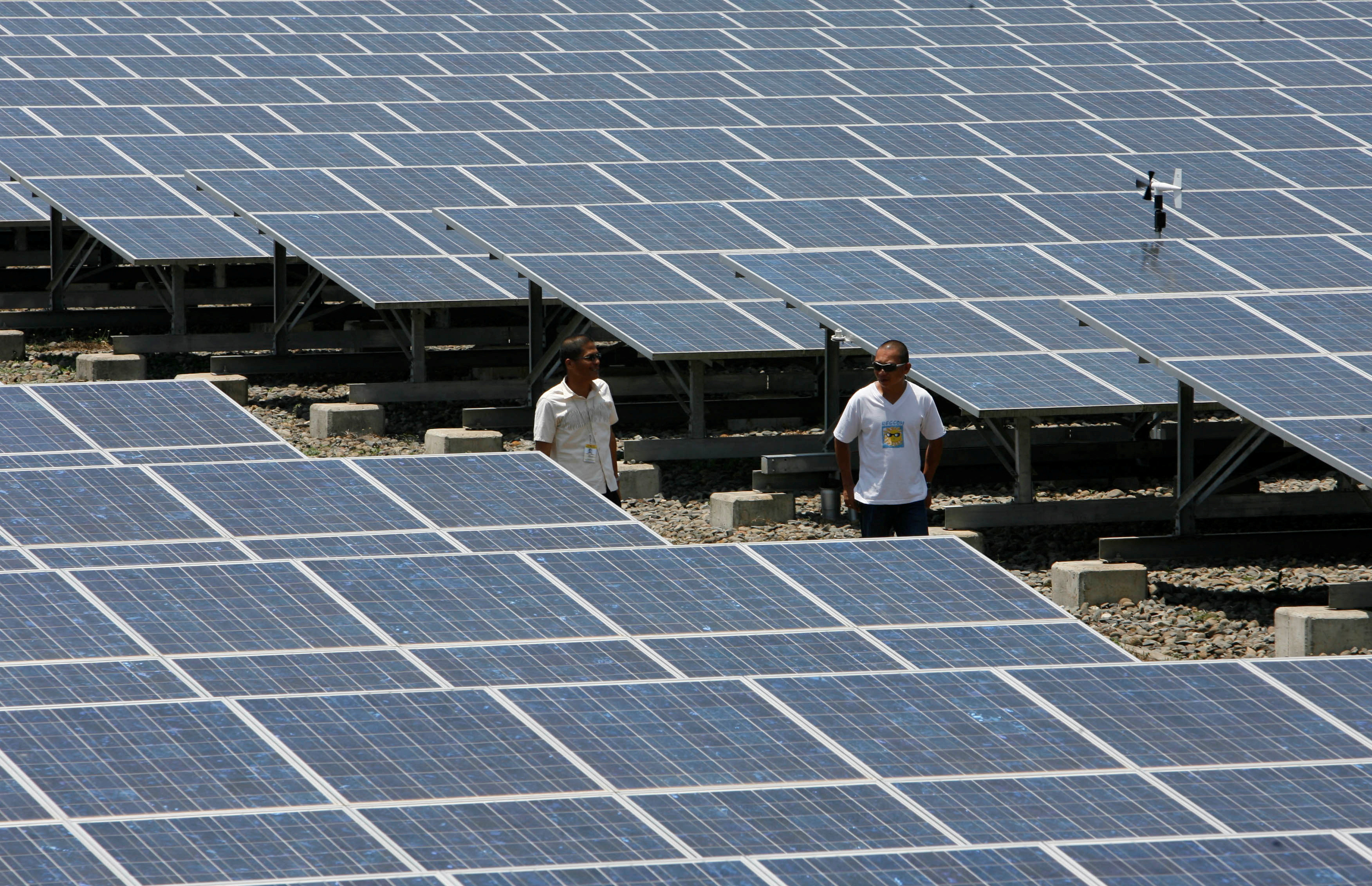 Plant manager of Cagayan Electric Power and Light Co. Inc walks past solar panels installed in Indahag village in Cagayan De Oro