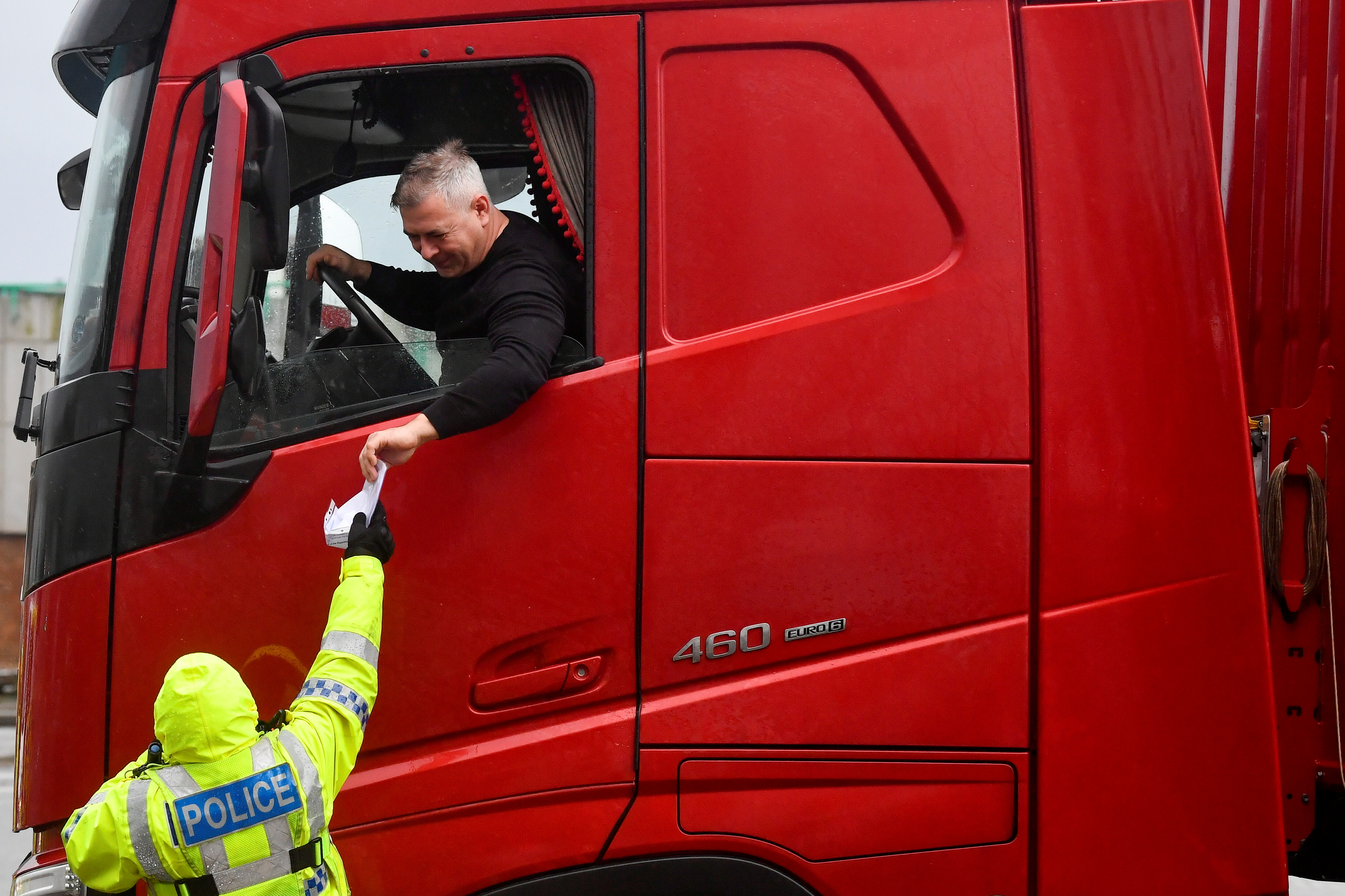 A police officer checks the documentation of a lorry driver upon his arrival to the Port of Dover