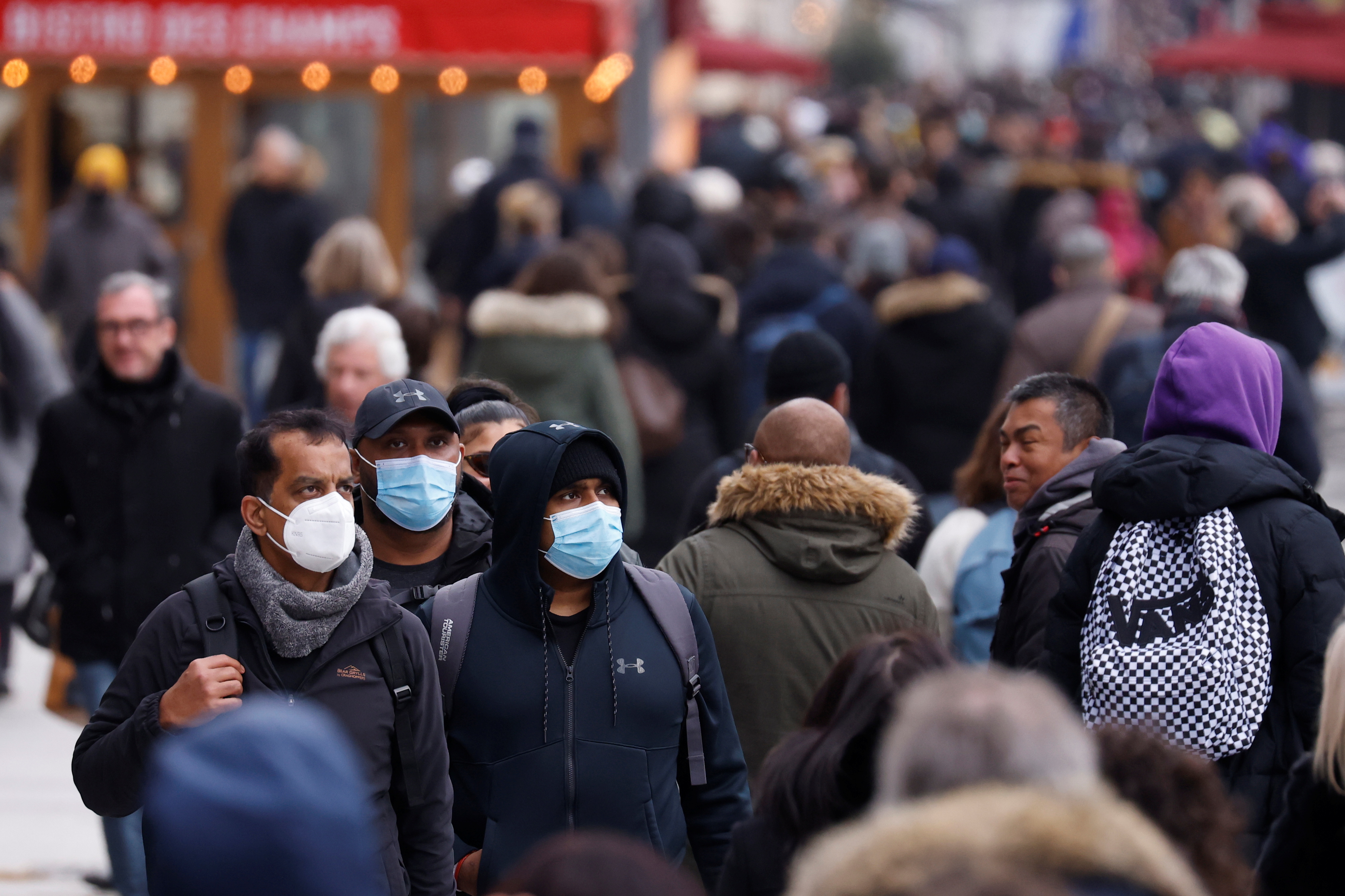 People, wearing protective face masks, walk on the Champs Elysees Avenue in Paris amid the coronavirus disease (COVID-19) outbreak in France, December 6, 2021. REUTERS/Gonzalo Fuentes