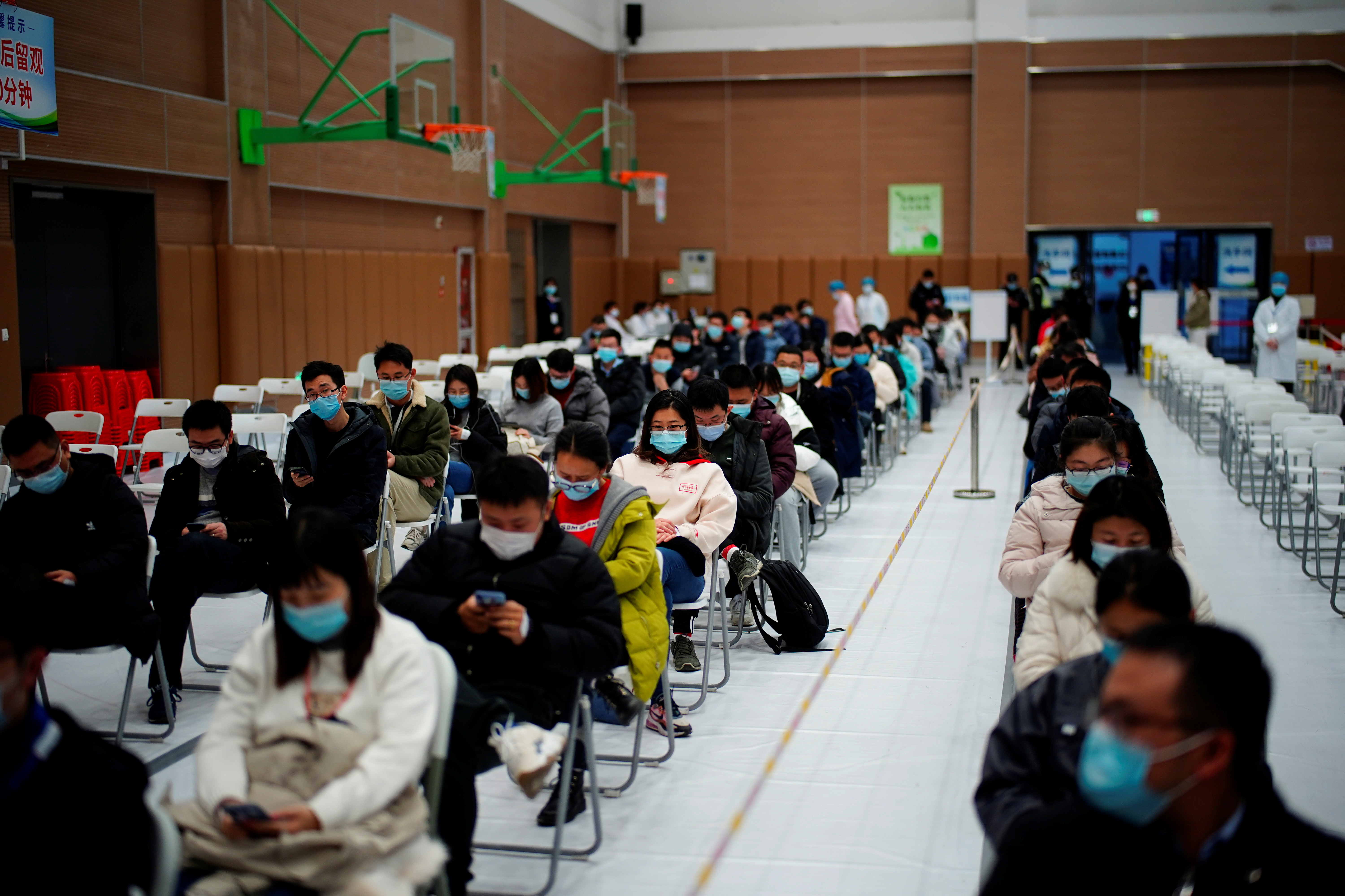 People sit at a vaccination site after receiving a dose of a coronavirus disease (COVID-19) vaccine, in Shanghai