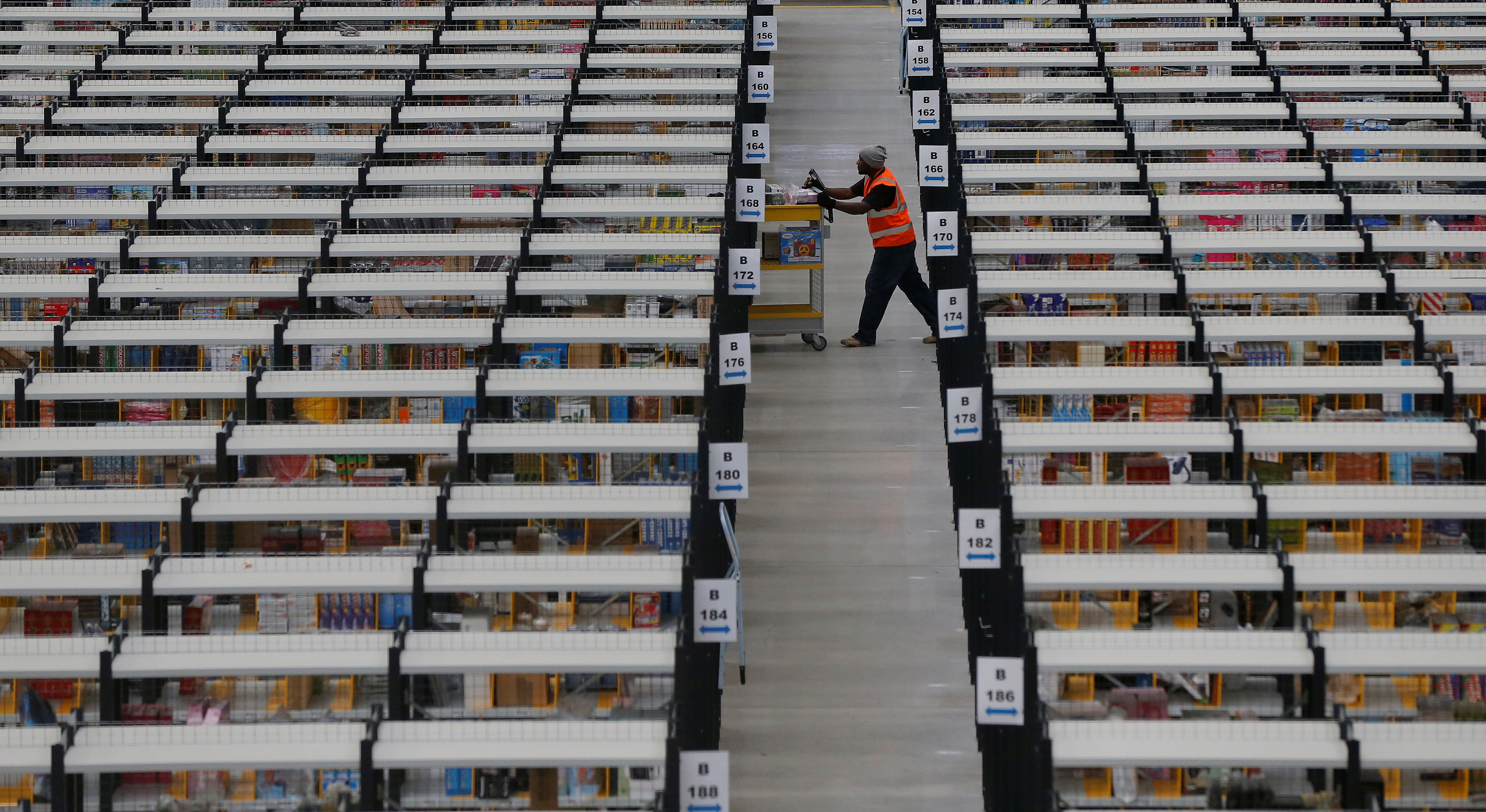 A worker collects orders at Amazon's fulfilment centre in Rugeley, central England December 11, 2012.  REUTERS/Phil Noble