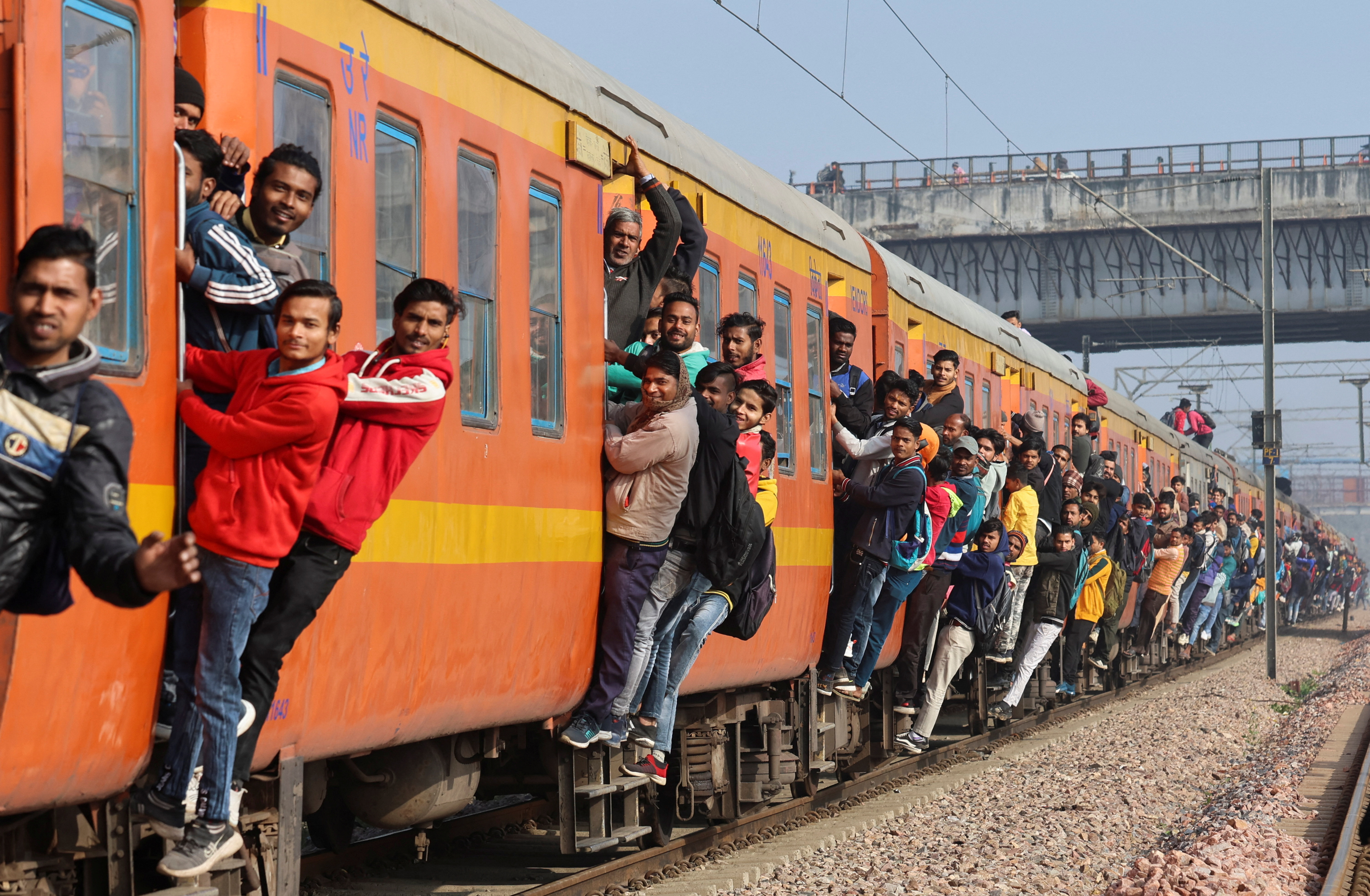 Commuters travel on a crowded train near a railway station in Ghaziabad, on the outskirts of New Delhi