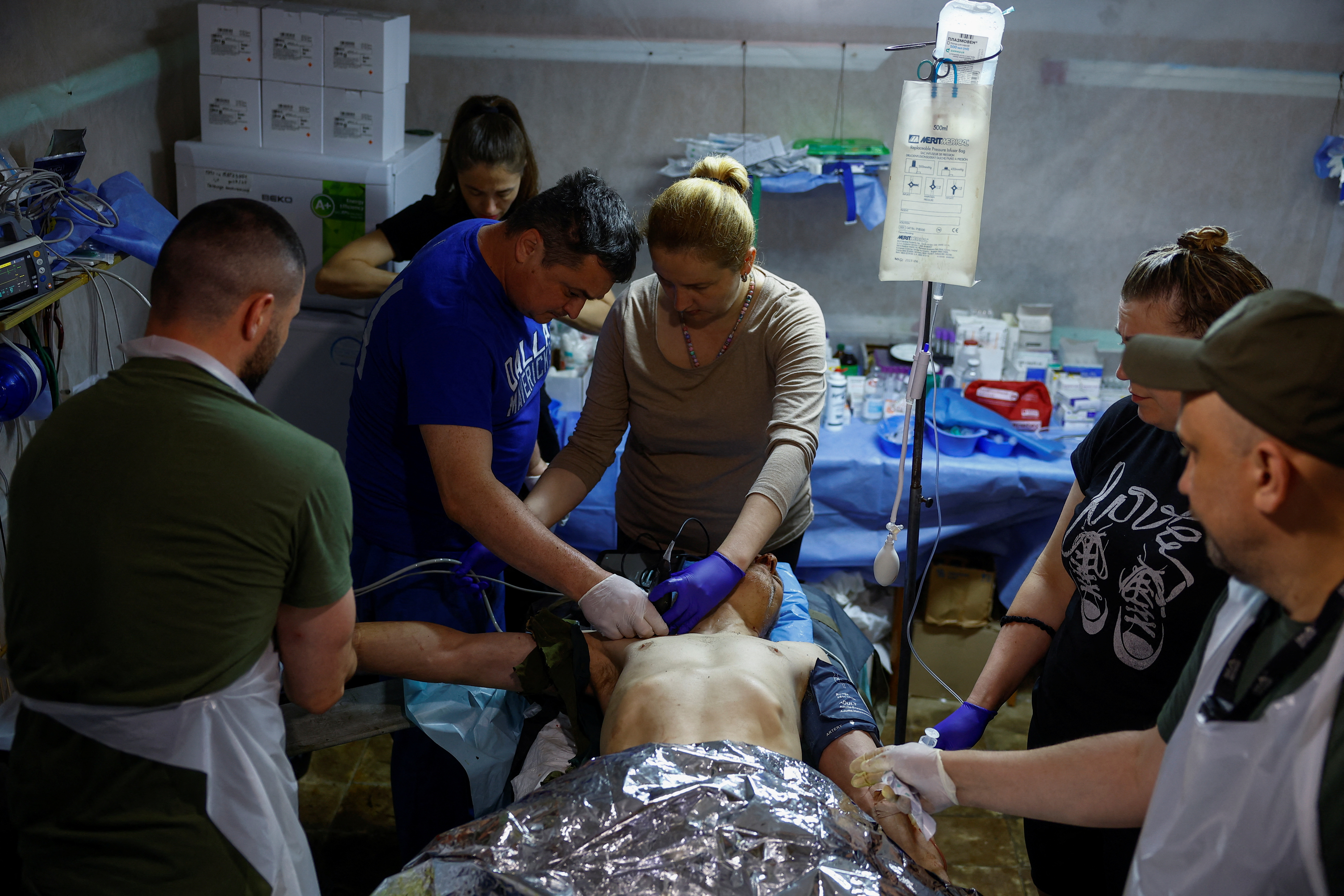 Medics provide a treatment to injured Ukrainian serviceman Vitalii at a stabilisation point near a front line in Kharkiv region
