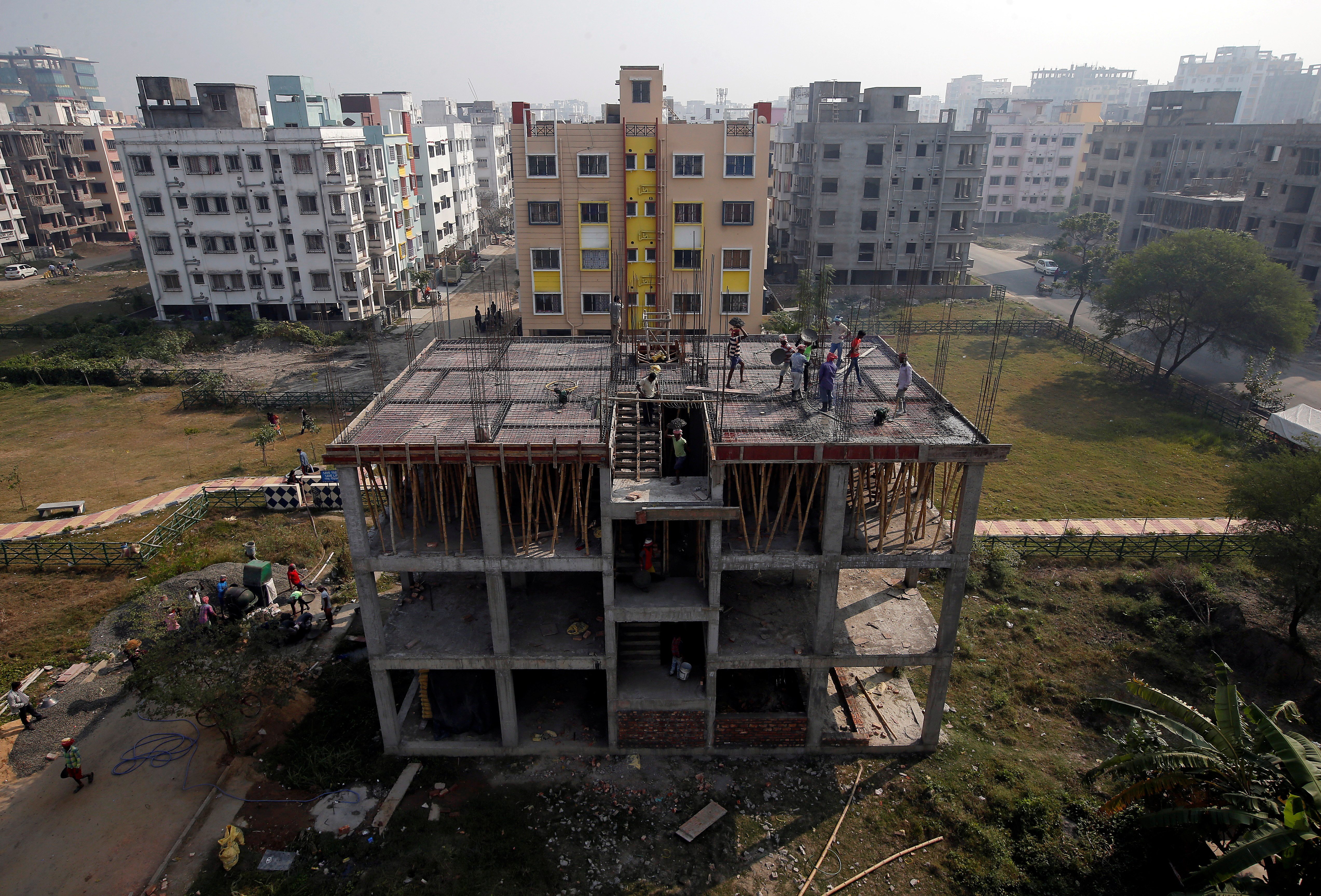 Labourers work at a construction site of a residential building on the outskirts of Kolkata