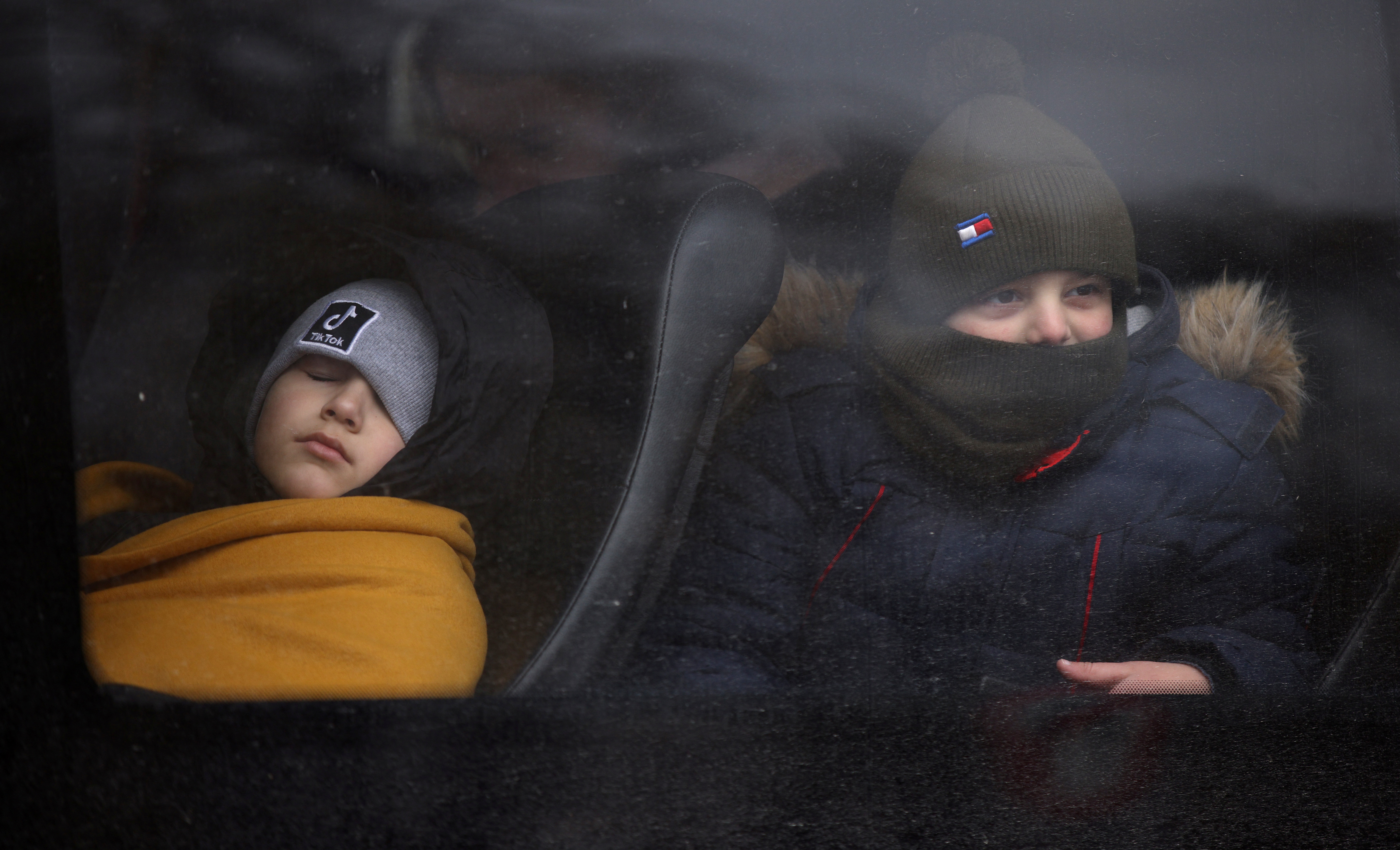 Children board a bus after fleeing from Russia's invasion of Ukraine, at the border crossing in Siret, Romania, February 28, 2022. REUTERS/Stoyan Nenov