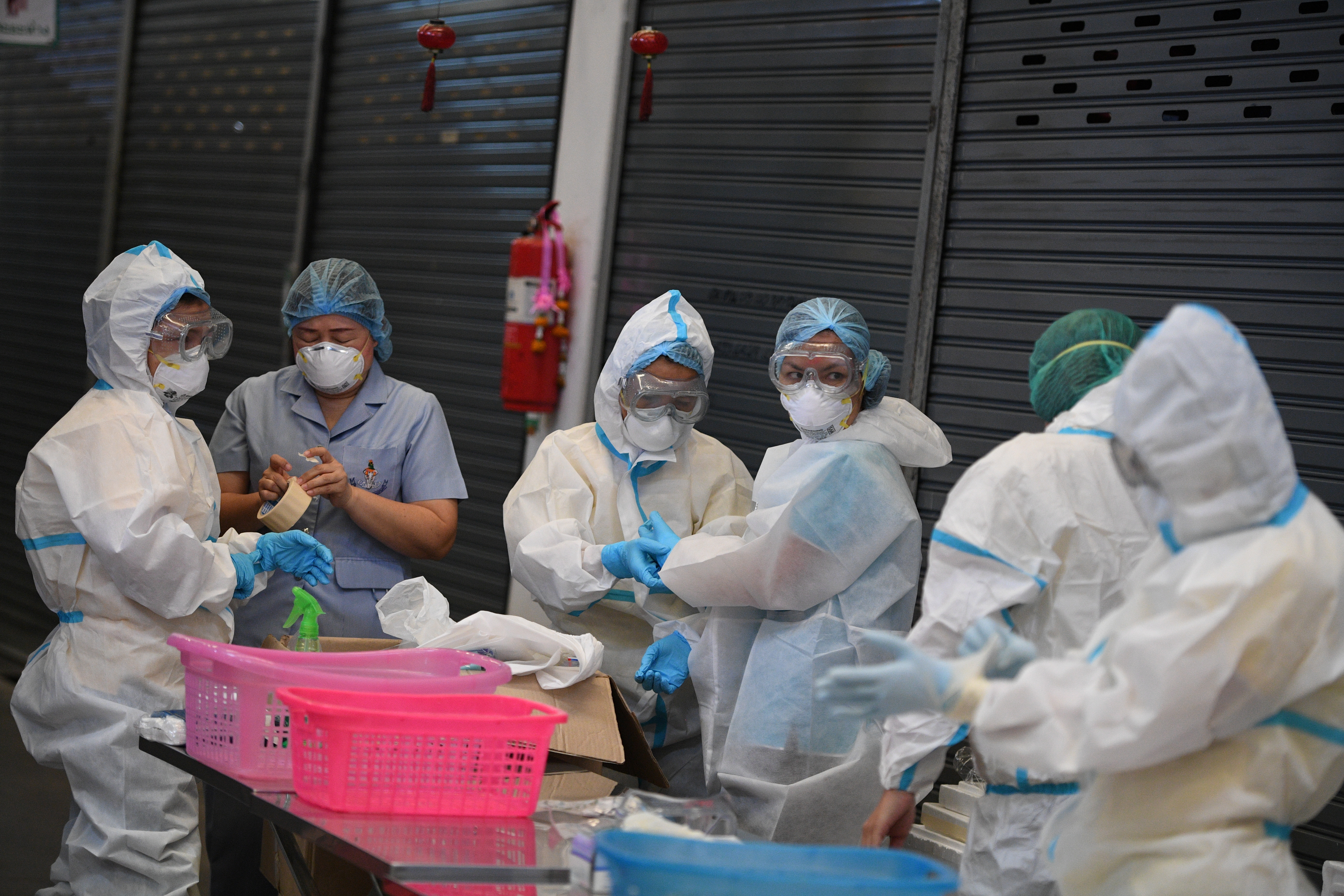 Health workers get ready to collect samples for further testing at Thanon Mitr Market in Bangkok