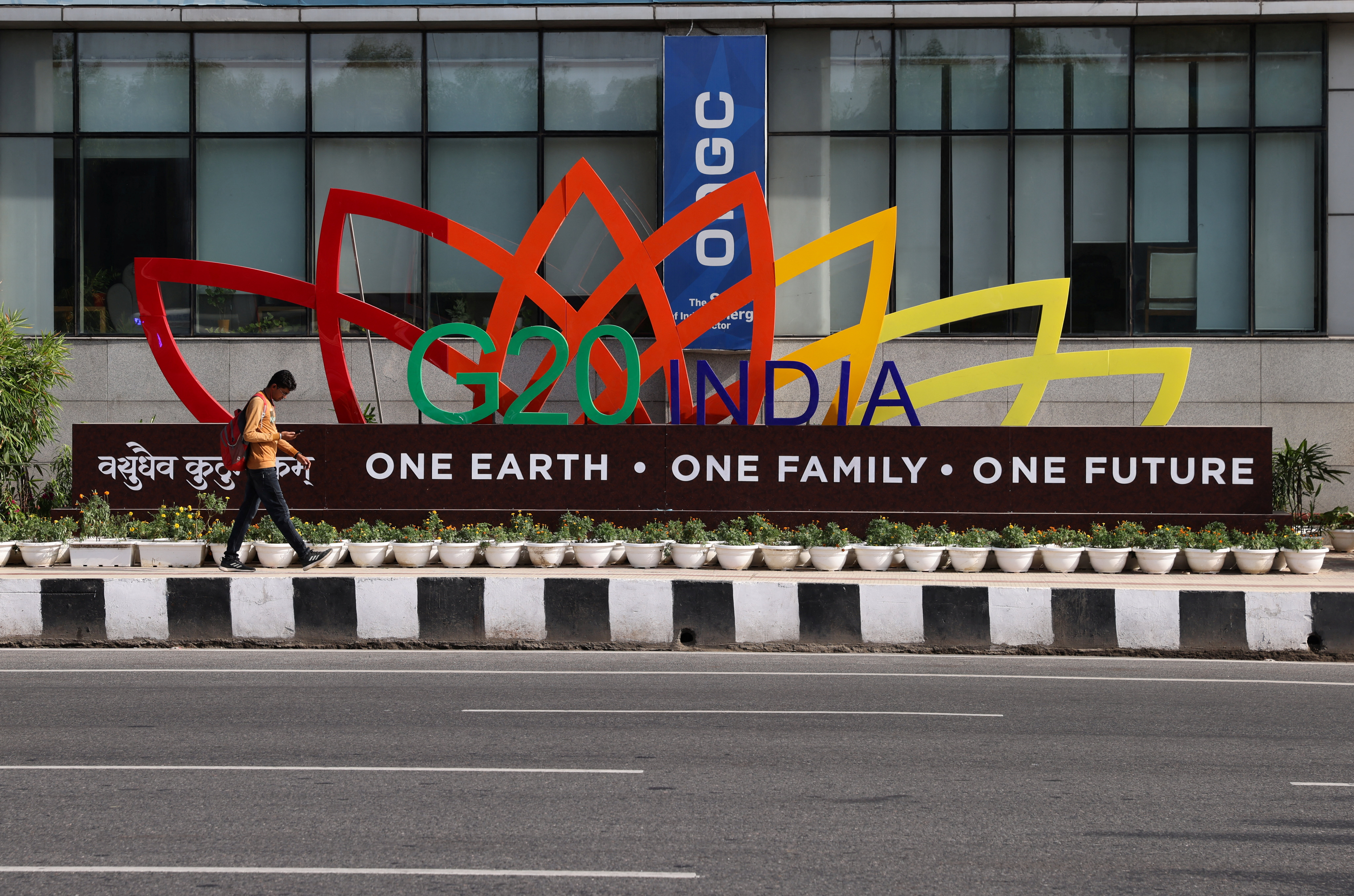 A man walks past a model of the G20 logo outside a metro station ahead of the G20 Summit in New Delhi