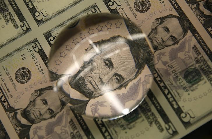 Sheets of Lincoln five dollar bill are seen through magnifying glass at  Bureau of Engraving and Printing in Washington
