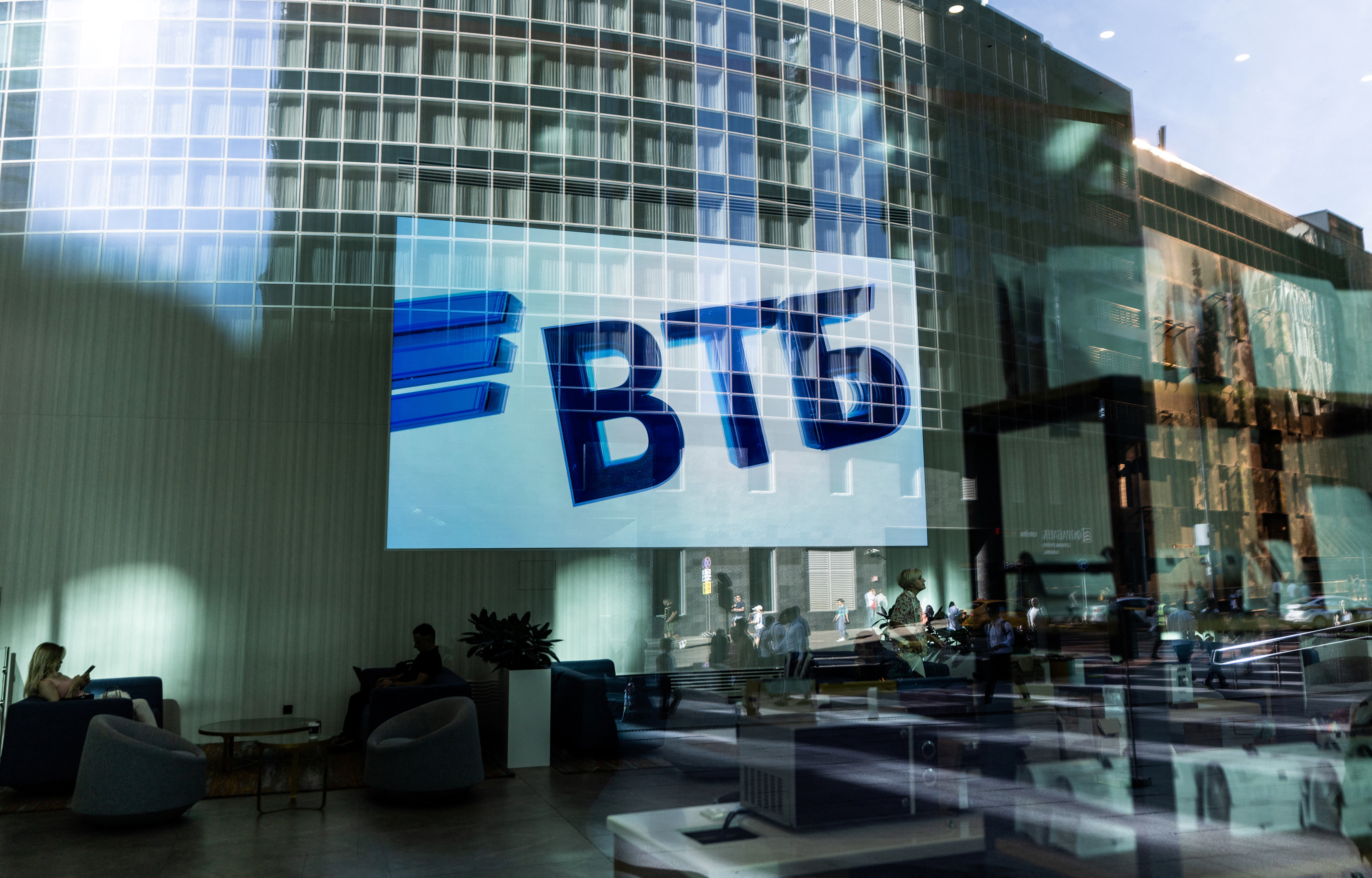 A VTB ngân hàng logo is seen on screen through a window in the Moscow International Business Centeron a sunny day in Moscow