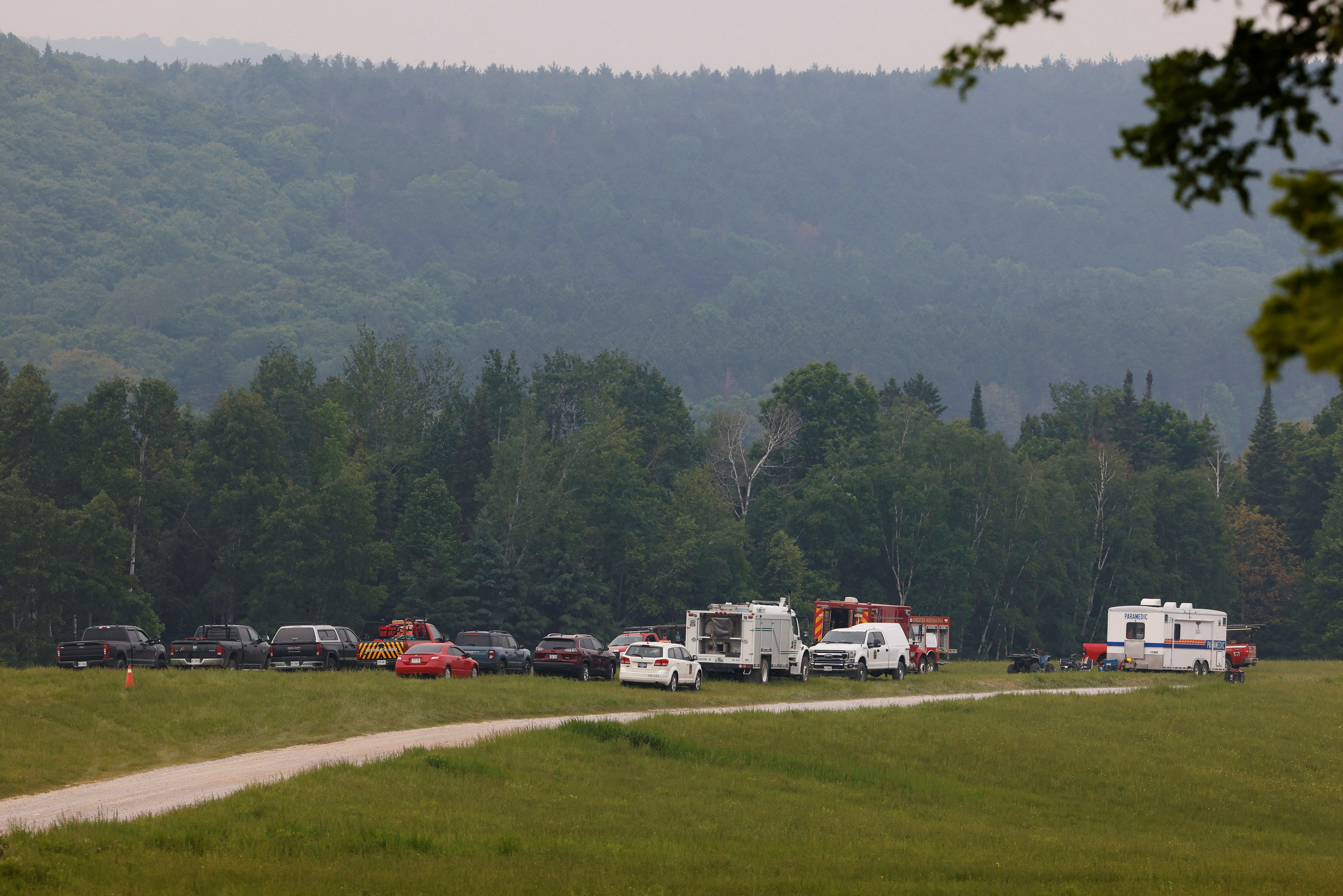 Emergency responders gather in a staging area near a forest fire that has been burning since Sunday on the shore of Centennial Lake in the Township of Greater Madawaska
