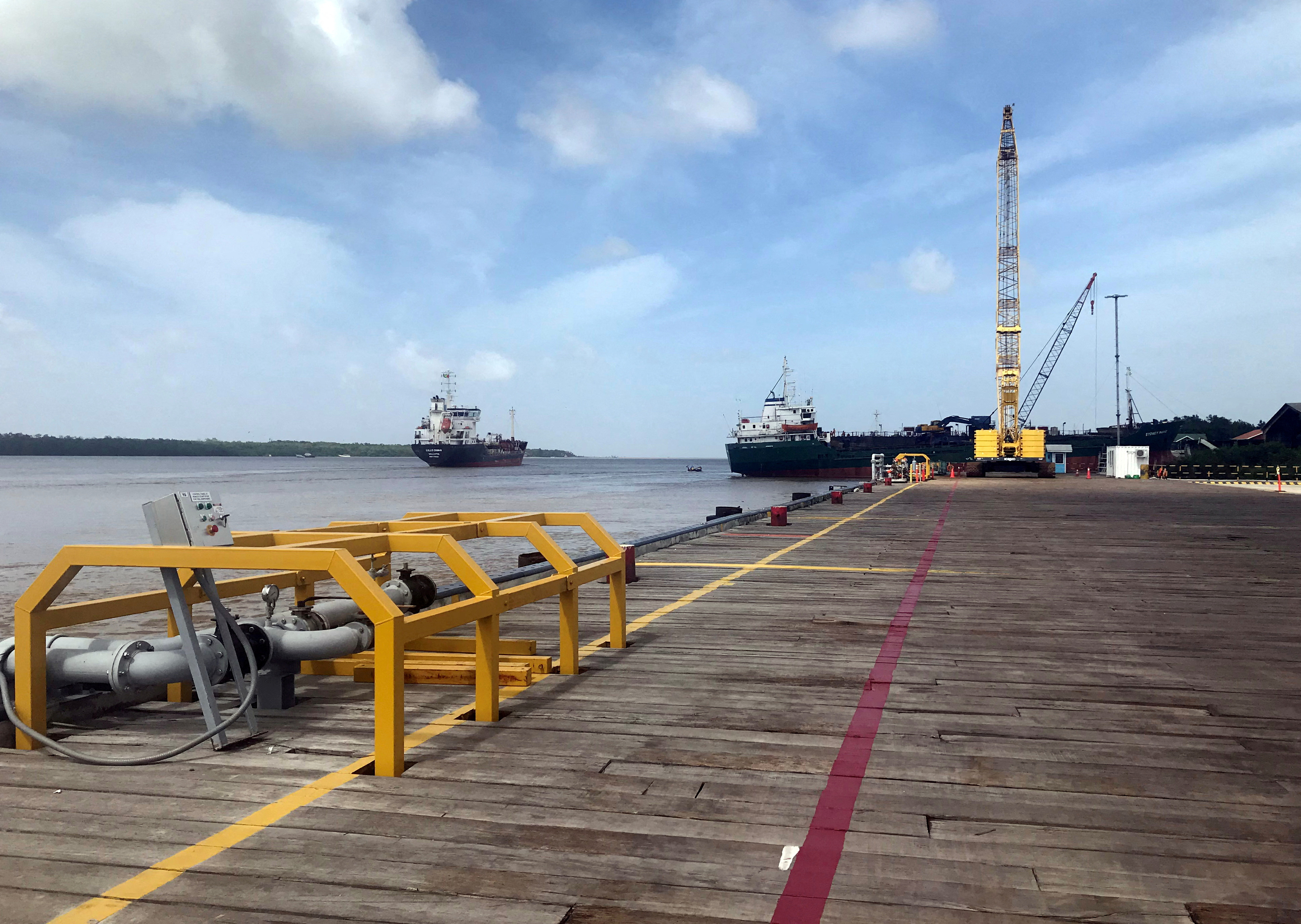 Vessels carrying supplies for an offshore oil platform operated by Exxon Mobil are seen at the Guyana Shore Base Inc wharf on the Demerara River south of Georgetown