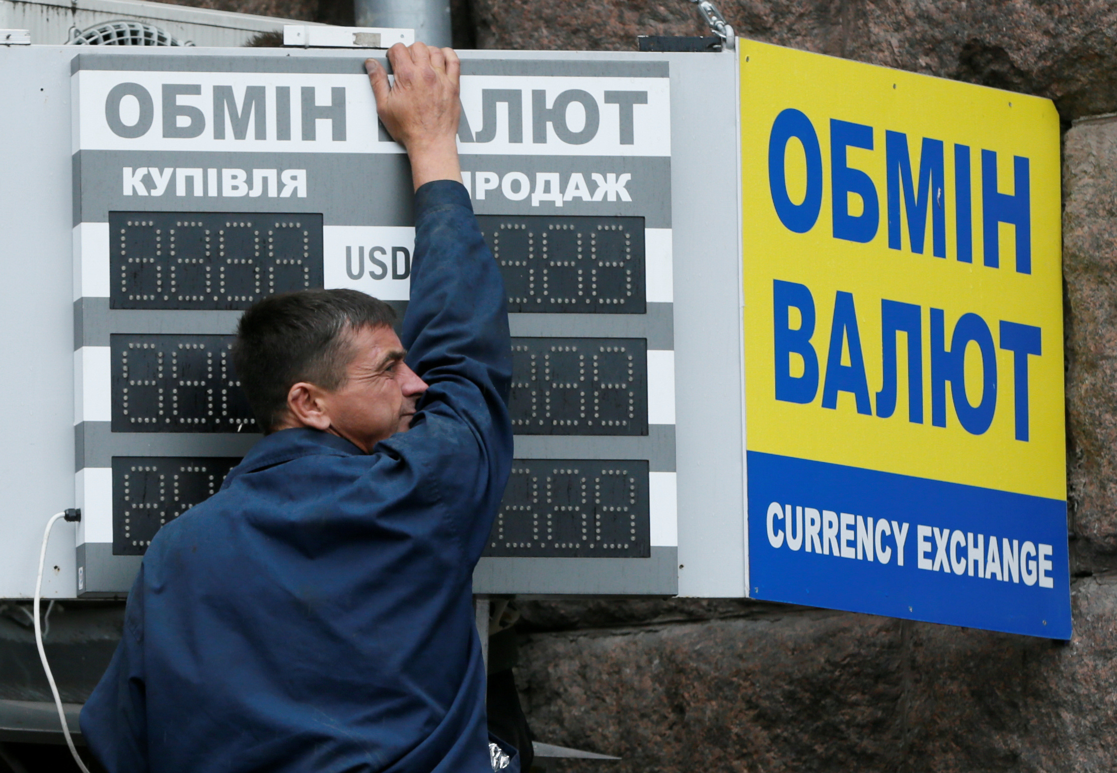 Man arranges board outside currency exchange office in Kiev