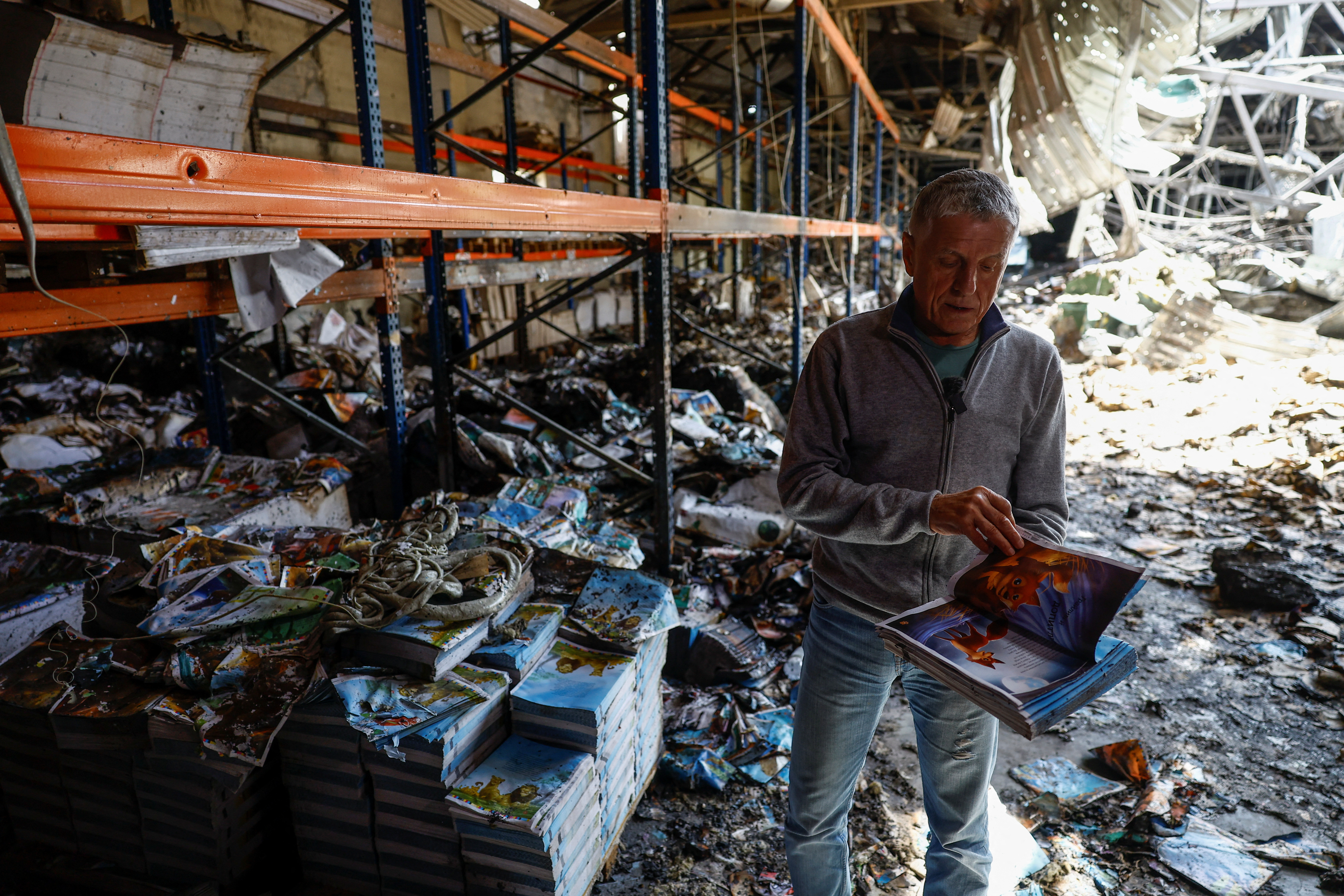 Sergii Polituchyi, Ukrainian publisher and businessman, shows an example of a book for kids inside of his printing house, which was heavily damaged by a recent Russian missile strike, in Kharkiv
