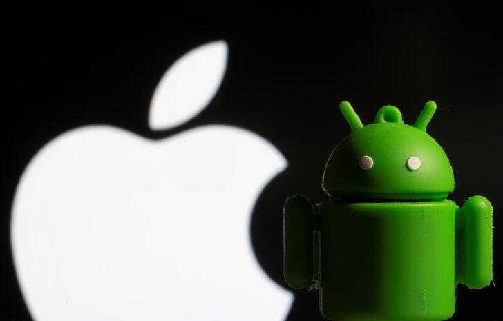 A 3D printed Android mascot Bugdroid is seen in front of the Apple logo in this illustration