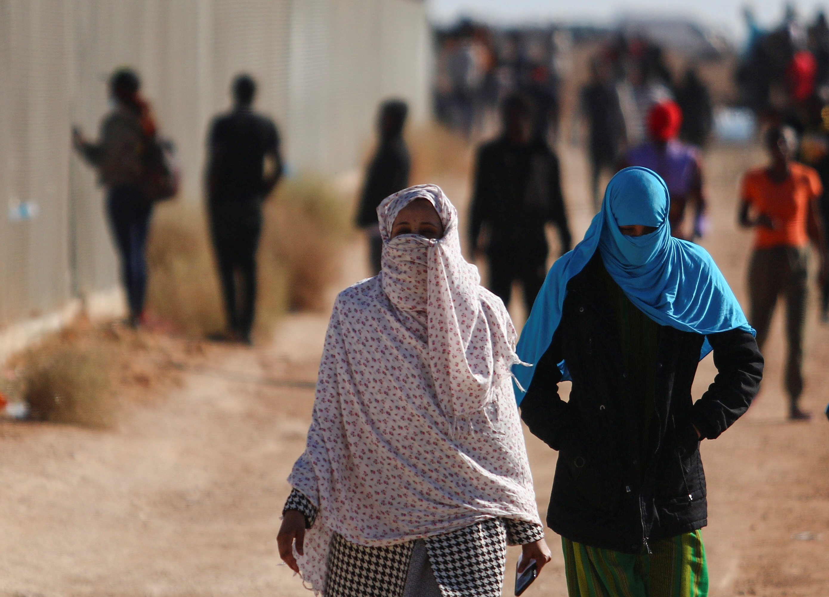 Migrants walk outside the Kokkinotrimithia refugee camp on the outskirts of Nicosia