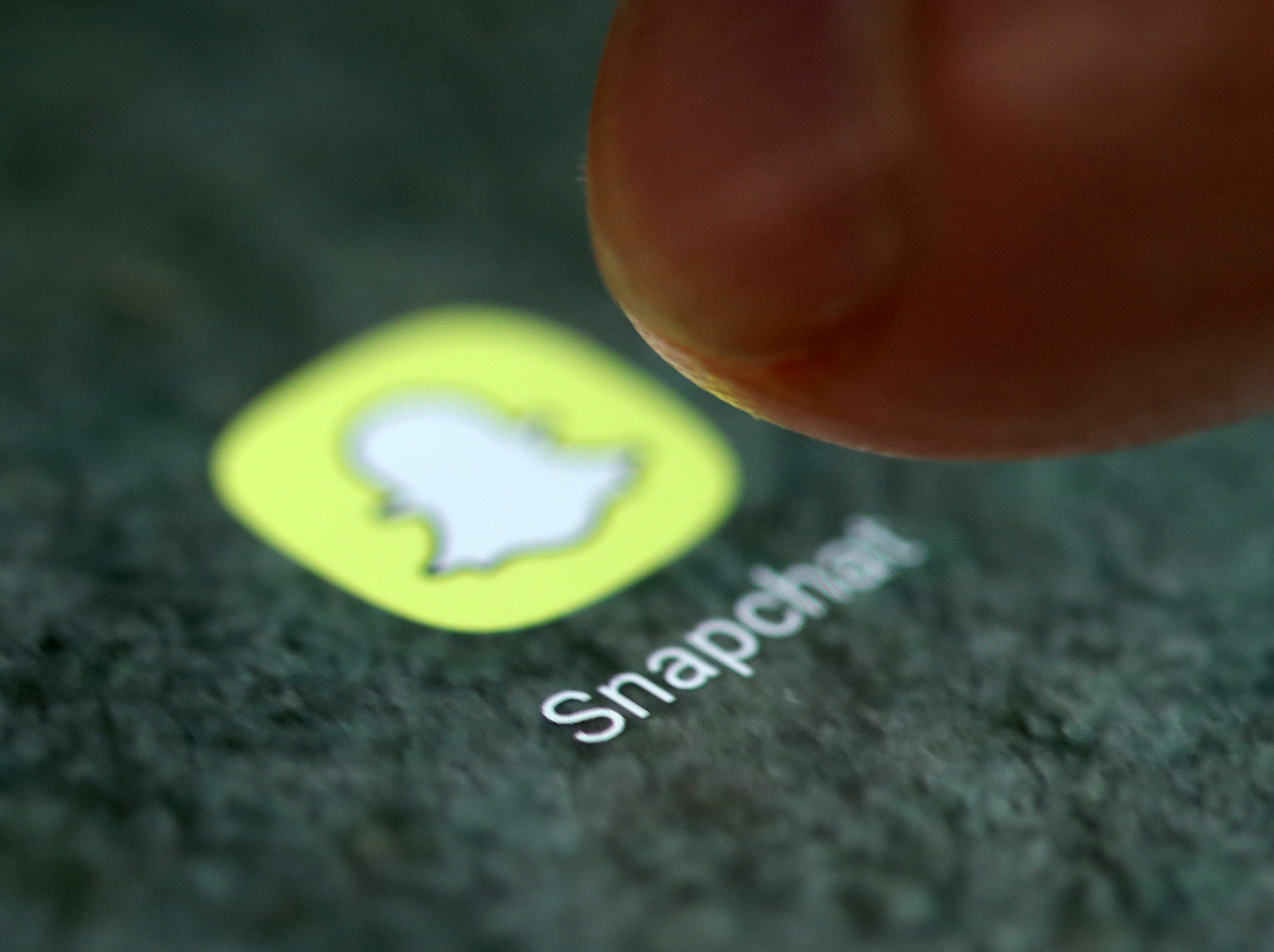 The Snapchat app logo is seen on a smartphone in this illustration