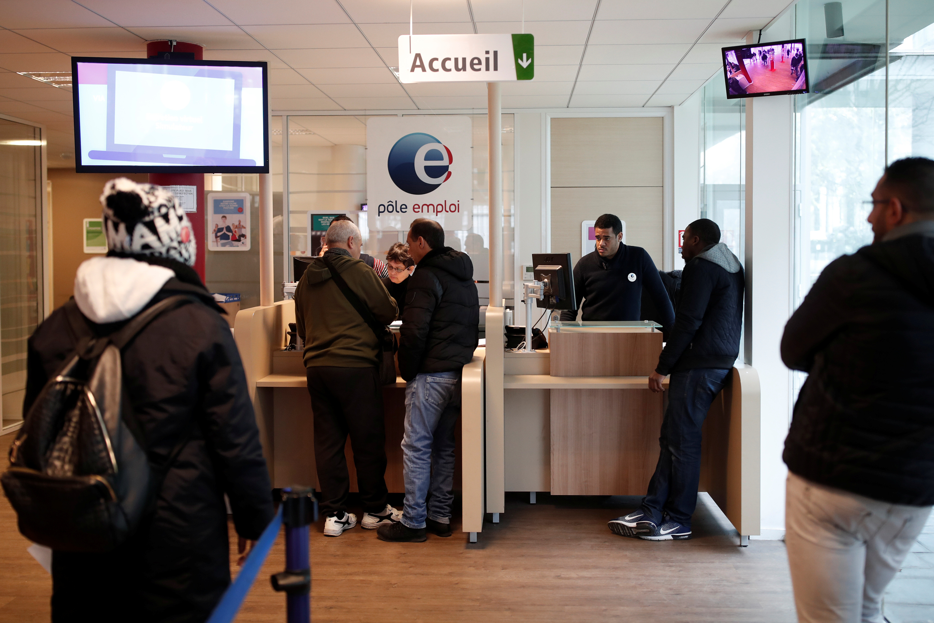 Job seekers speak to staff at a National Agency for Employment (Pole Emploi) office in Aubervilliers